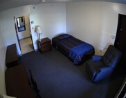 DOVER AIR FORCE BASE, Del. – This is an example of a dorm room at DAFB. Furniture includes a twin bed, nightstand, dresser, desk, recliner and several lamps. Occupants share a bathroom and get their own refrigerator and microwave. Dover began a new initiative in January 2008 to ensure that all incoming Airmen get a clean room with freshly painted walls and a made bed. (U.S. Air Force photo/Senior Airman James Bolinger)