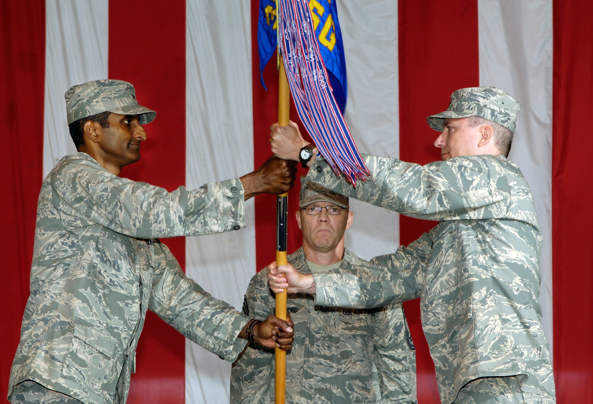 Col. Balan Ayyar, 305th Air Mobility Wing commander, hands over the 305th Mission Support Group guidon to Col. Michael Carrell, incoming 305th MSG commander, at a change of command ceremony July 14. (U.S. Air Force photo/Kenn Mann)