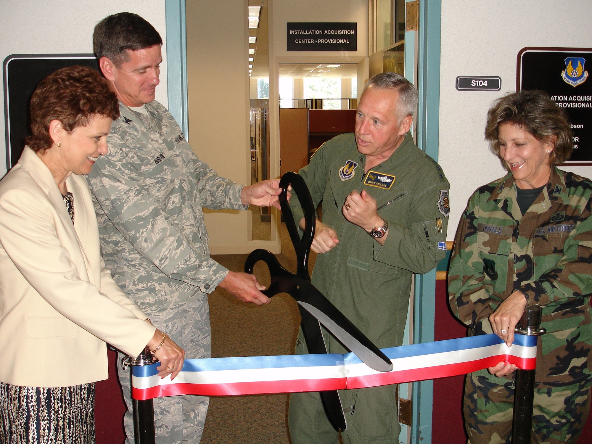 A milestone in Air Force Acquisition Transformation took place July 1 at Wright-Patterson Air Force Base with the official opening of the Installation Acquisition Center.  The Center provides strategic guidance for five regional Installation Acquisition Groups and is designed to streamline installation-level purchases across the continental U.S.  Pictured at the ribbon cutting are Installation Acquisition Center deputy director Marie McManus, IAC director Col. Mark Hobson, Air Force Materiel Command commander Gen. Bruce Carlson, and AFMC acting director of Contracting Col. Jacqueline Dovale.  (U.S. Air Force photo/Capt. Bob Everdeen)