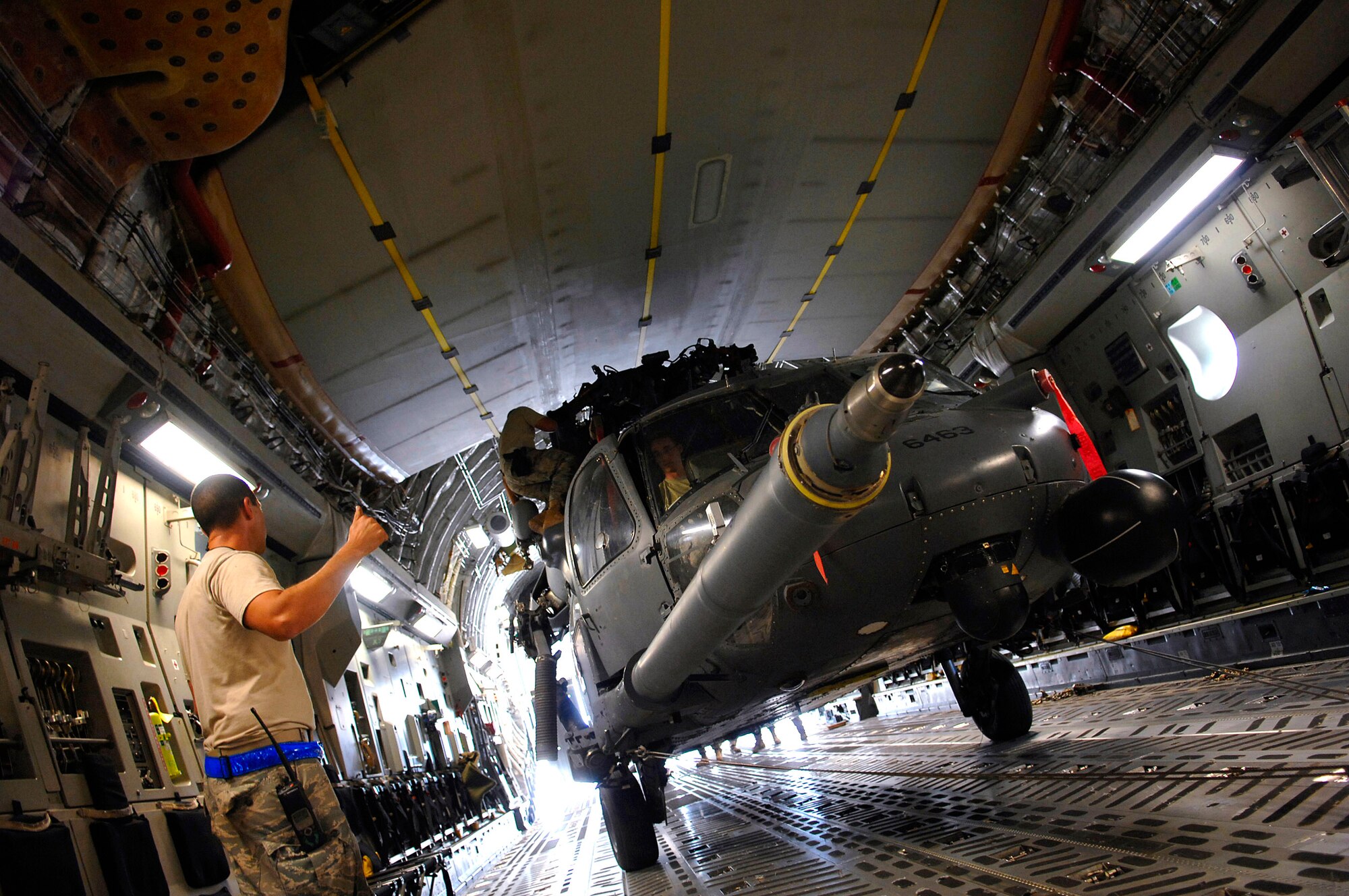 Tech. Sgt. Joseph Herrera gives a thumbs up to loadmasters during an upload of an HH-60 Pave Hawk into a C-17 Globemaster III July 12 at Joint Base Balad, Iraq. The helicopter is configured in a folded position that allows it to be loaded with enough clearance all around. Sergeant Herrera is a 64th Expeditionary Helicopter Maintenance Unit crew chief deployed from Davis-Monthan Air Force Base, Ariz. (U.S. Air Force photo/Senior Airman Julianne Showalter) 