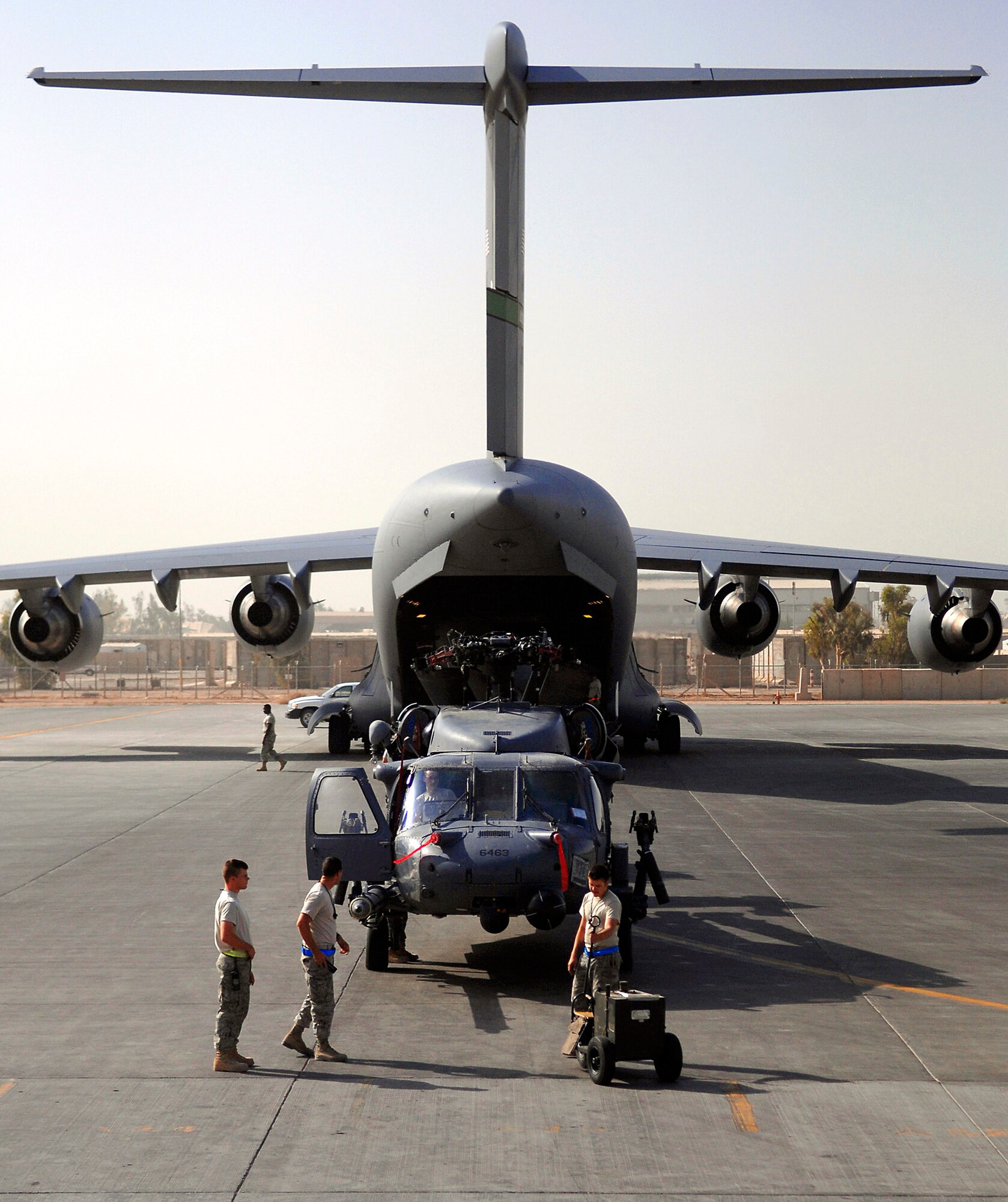 Airmen assigned to the 64th Expeditionary Helicopter Maintenance Unit prepare an HH-60 Pave Hawk for loading onto a C-17 Globemaster III July 12 at Joint Base Balad, Iraq. The helicopter is in a folded configuration in order to fit into the hull of the aircraft. The Airmen are deployed from Davis-Monthan Air Force Base, Ariz. (U.S. Air Force photo/Senior Airman Julianne Showalter) 
