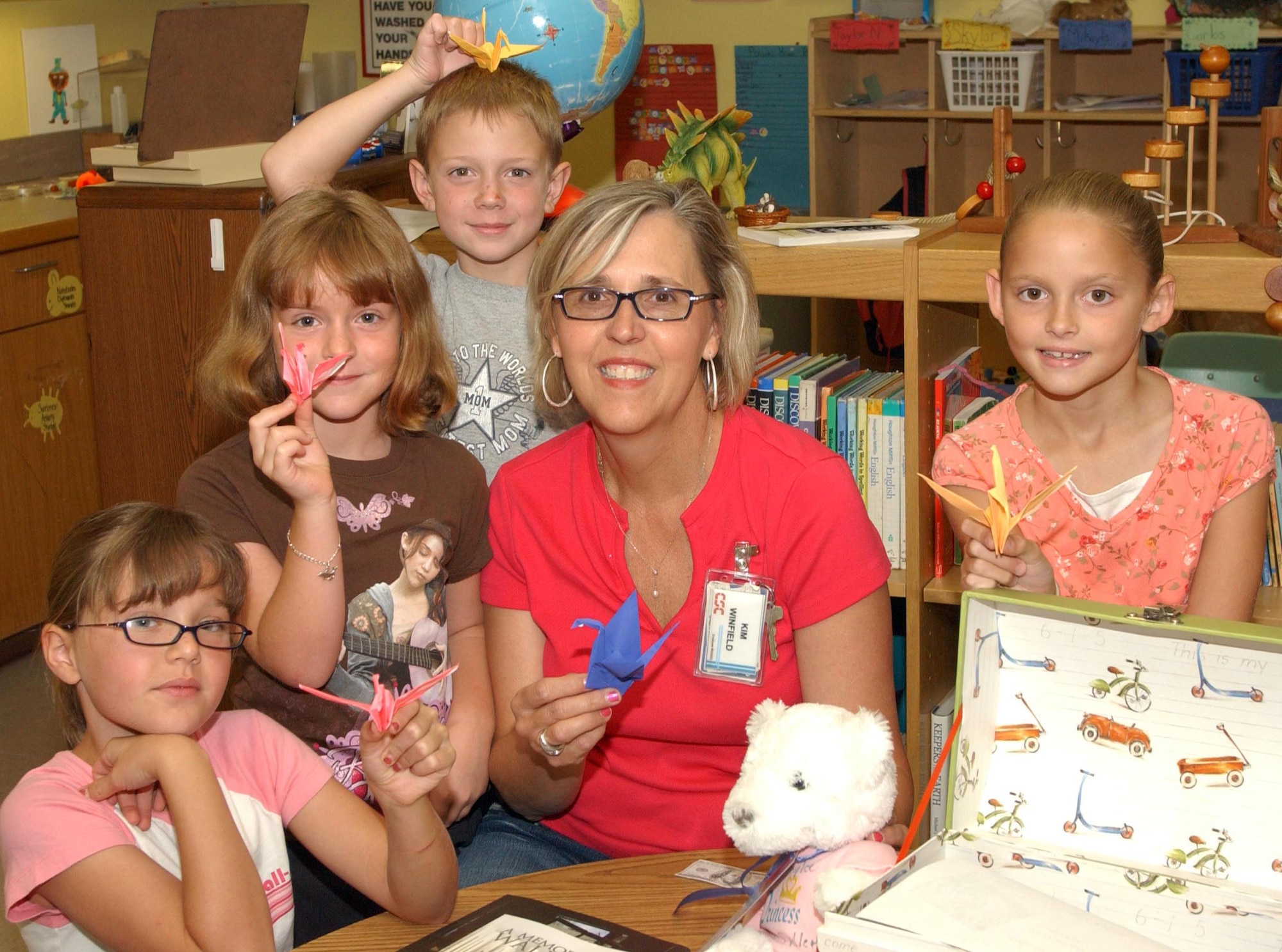 Children at the Vance Air Force Base Youth Center, Okla., show paper cranes they have just folded as part of the Hope Trunk project, founded by the Oklahoma Memorial Foundation. Holding cranes are (left to right) McKenzie Franklin, Danae Stidham, Sam Keith, Kim Winfield, and Taylor McClelland. The program is designed to teach about the effects of discrimination. 