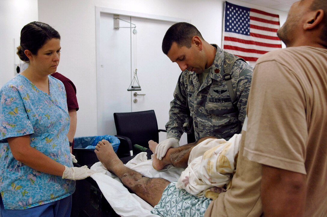 Maj. (Dr.) Michael Charlton and Tech. Sgt. Judy Hickman examine the healing progress of the leg of an Iraqi policeman July 1 at Joint Base, Balad, Iraq. The injury is the result of an improvised explosive device attack earlier this year. Major Charlton, a 332nd Expeditionary Medical Operations Squadron orthopedic trauma surgeon, and Sergeant Hickman, a 332nd EMDOS orthopedic technician, are both deployed from Lackland Air Force Base, Texas. (U.S. Air Force photo/Senior Airman Julianne Showalter) 