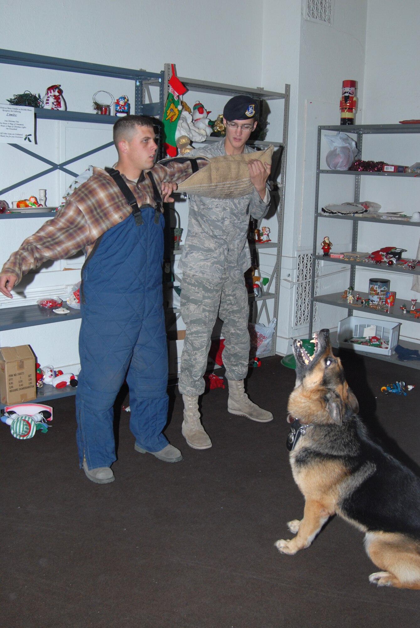 Senior Airman Ryan Knopf, 90th Security Forces Squadron, conducts a search of Senior Airman Daren Marshall, while his military working dog Boss provides watch.  Boss is a 6-year-old German Shepherd.