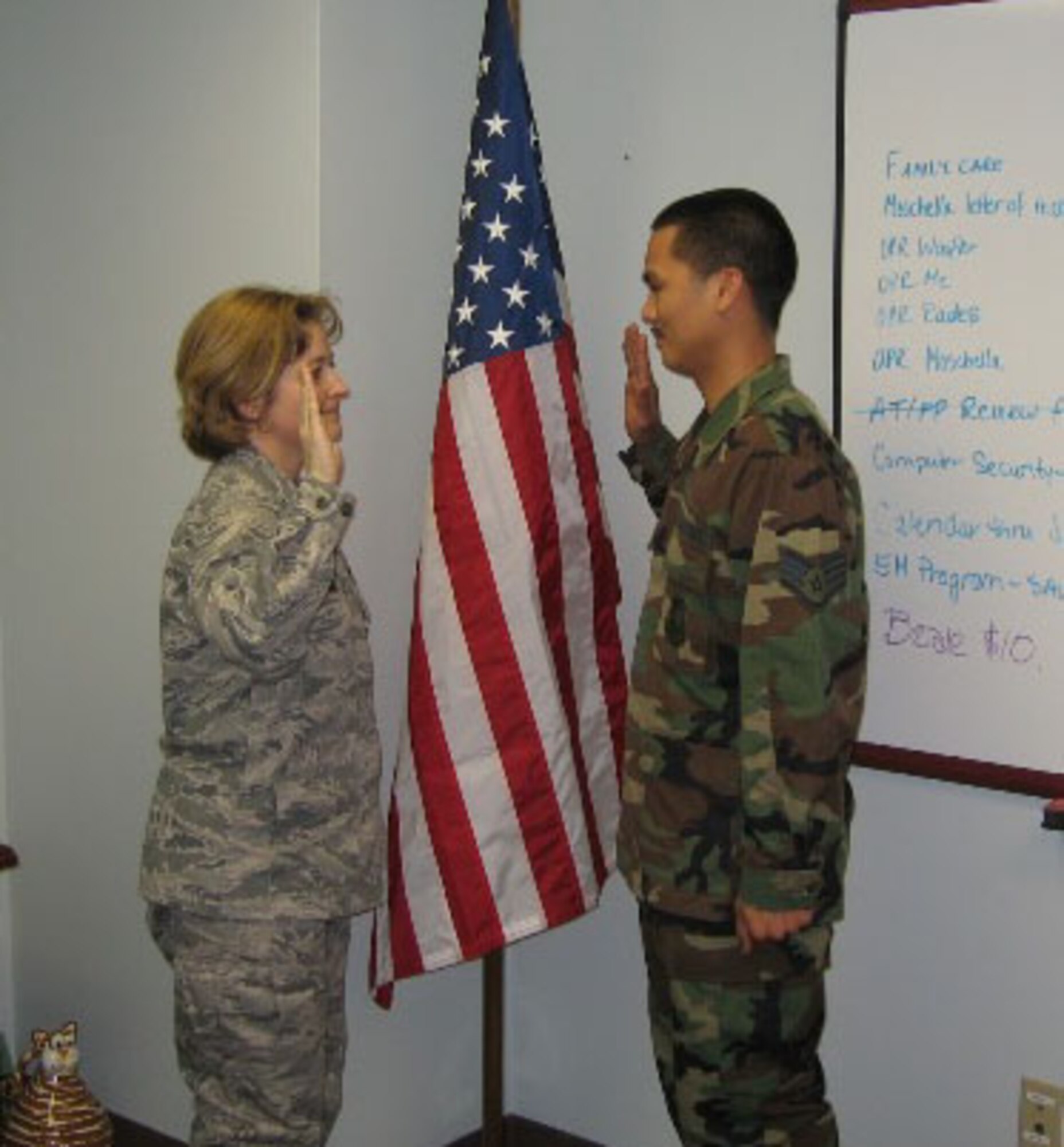 SEYMOUR JOHNSON AIR FORCE BASE, N.C. -- Staff Sgt. Alex Tadeo (right) reenlists in the Air Force Reserve during the July unit training assembly for another six years. Administering the oath of enlistment is 916th Civil Engineer Squadron Commander Lt. Col. Kerri Grimes. Sgt. Tadeo is a pest management craftsman.