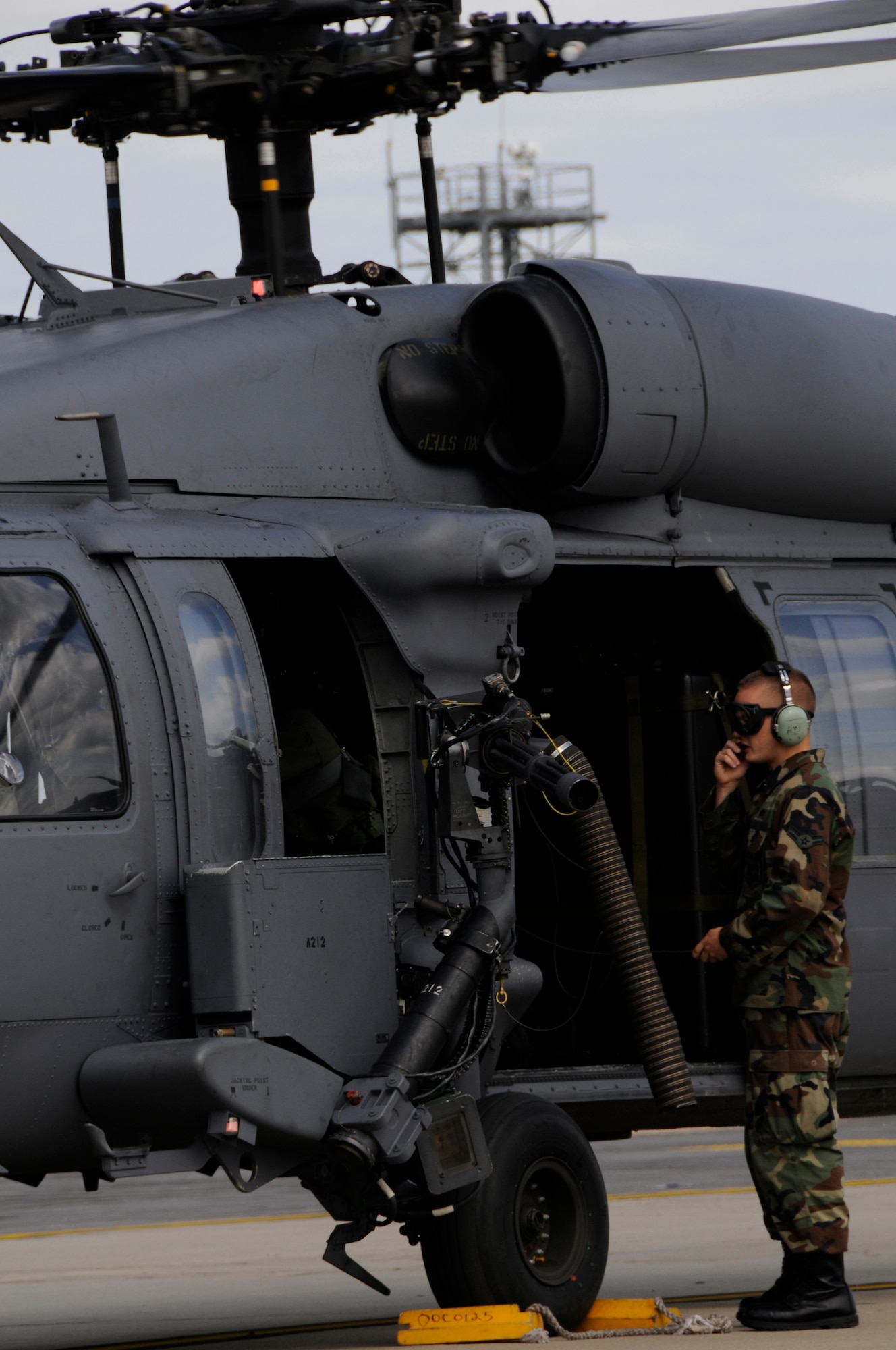 Airman 1st Class Christopher Jablonski, 48th Aircraft Maintenance Squadron HH-60G helicopter crew chief communicates with the pilot during shutdown procedures, July 10 at RAF Lakenheath, England. The helicopter returned from a training mission practicing marksmanship with their aerial gunners. (U.S. Air Force photo by Airman Perry Aston) 