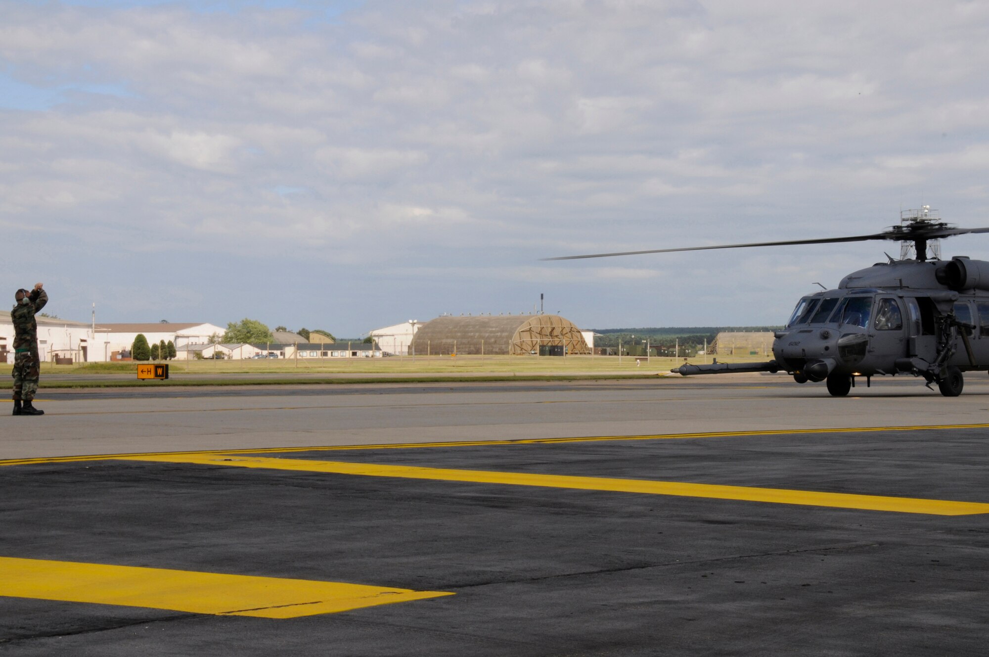 Airman 1st Class Christopher Jablonski, 48th Aircraft Maintenance Squadron HH-60G helicopter crew chief marshals in an HH-60G Pave Hawk, July 10 at RAF Lakenheath, England. The HH-60G Pave Hawk belongs to the 56th Rescue Squadron returning from a training mission. (U.S. Air Force photo by Airman Perry Aston) 