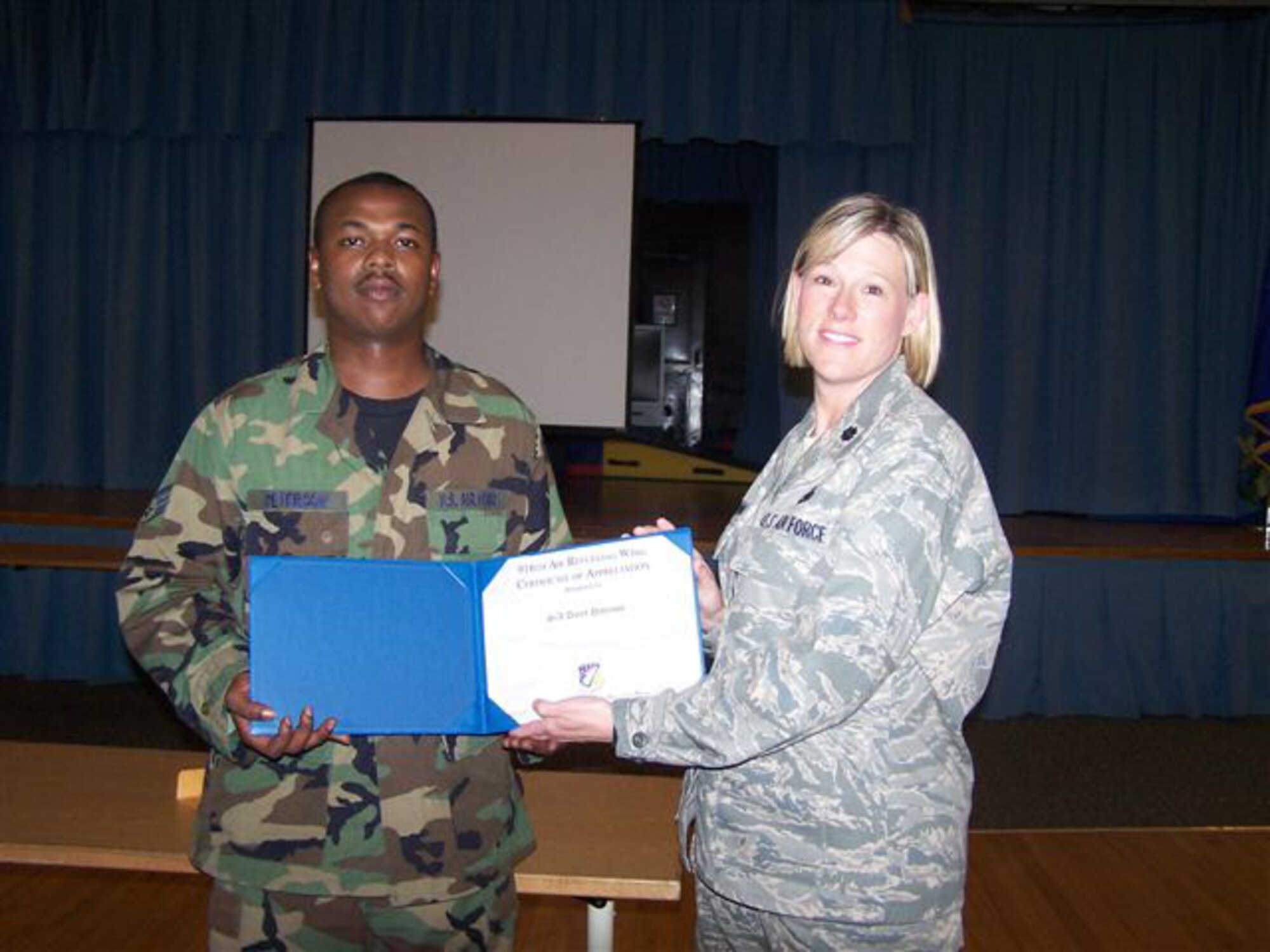 SEYMOUR JOHNSON AIR FORCE BASE, N.C. -- Senior Airman Daryl Peterson (left) receives a Get One Now award from Lt. Col. Ann Brown, commander of the 916th Logistics Readiness Squadron during the July unit training assembly. Airman Peterson earned the recruiting award by enlisting his friend into the Air Force Reserve.
