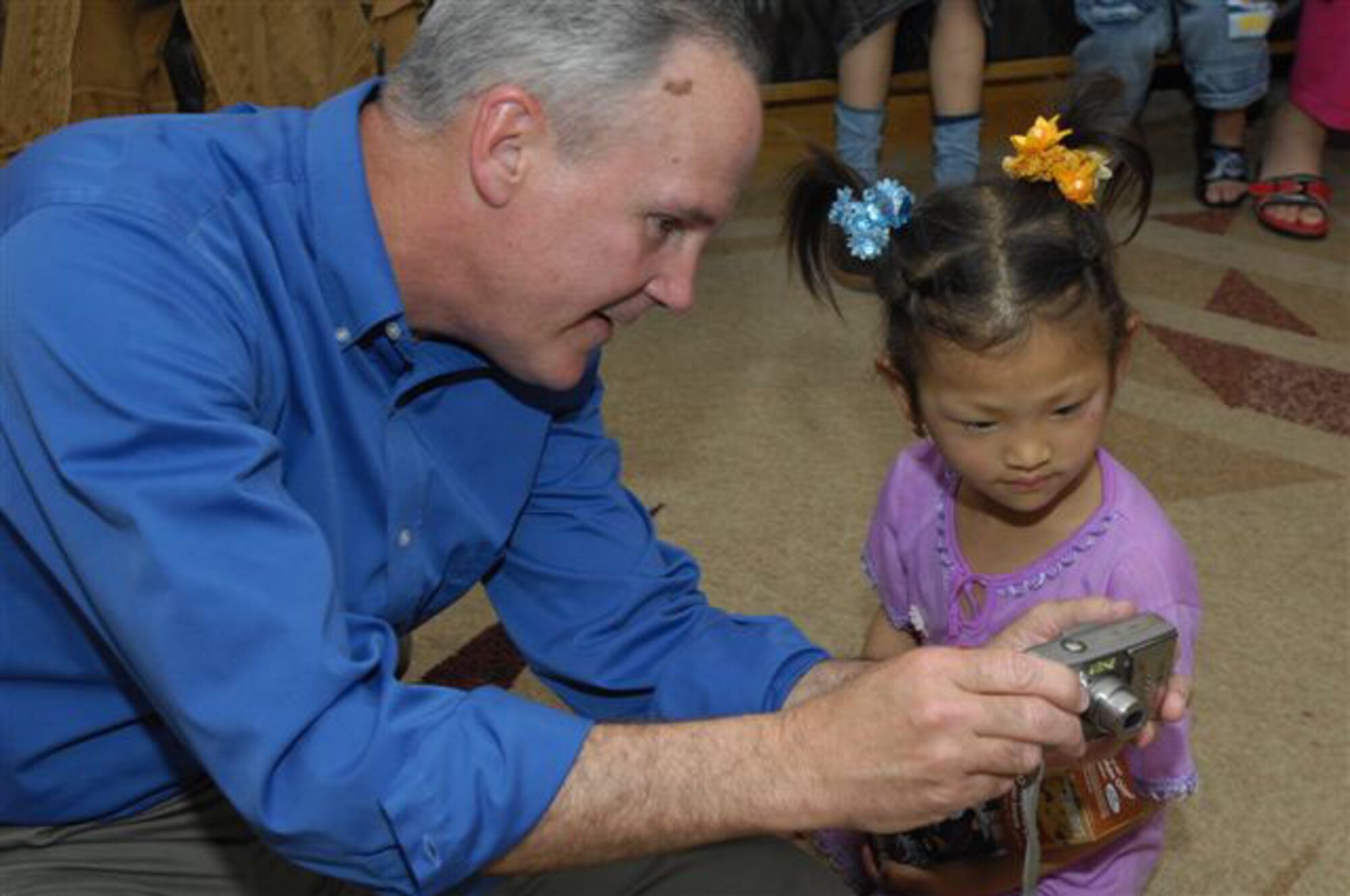 Col. Randall Guthrie shows one of the young patients her picture on his digital camera.
