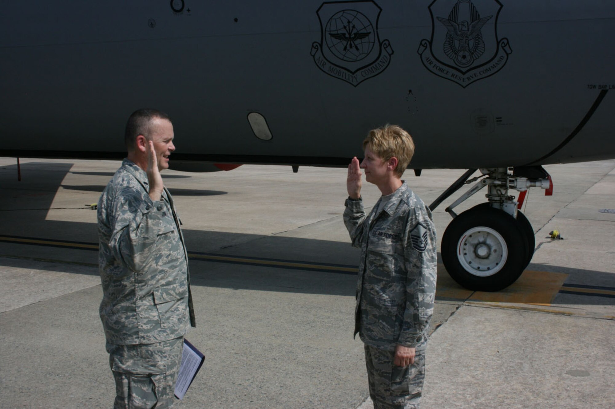 SEYMOUR JOHNSON AIR FORCE BASE, N.C. -- Col. James Horton (left), commander of the 916th Communications Squadron, re-enlists his wife, Master Sgt. Angela Horton, a Guard member with the 145th Airlift Wing in mid-July on the 916th ramp. The couple were deployed to Iraq together earlier this year and had planned to do the re-enlistment at their deployed location, but the colonel returned stateside before the ceremony could happen.