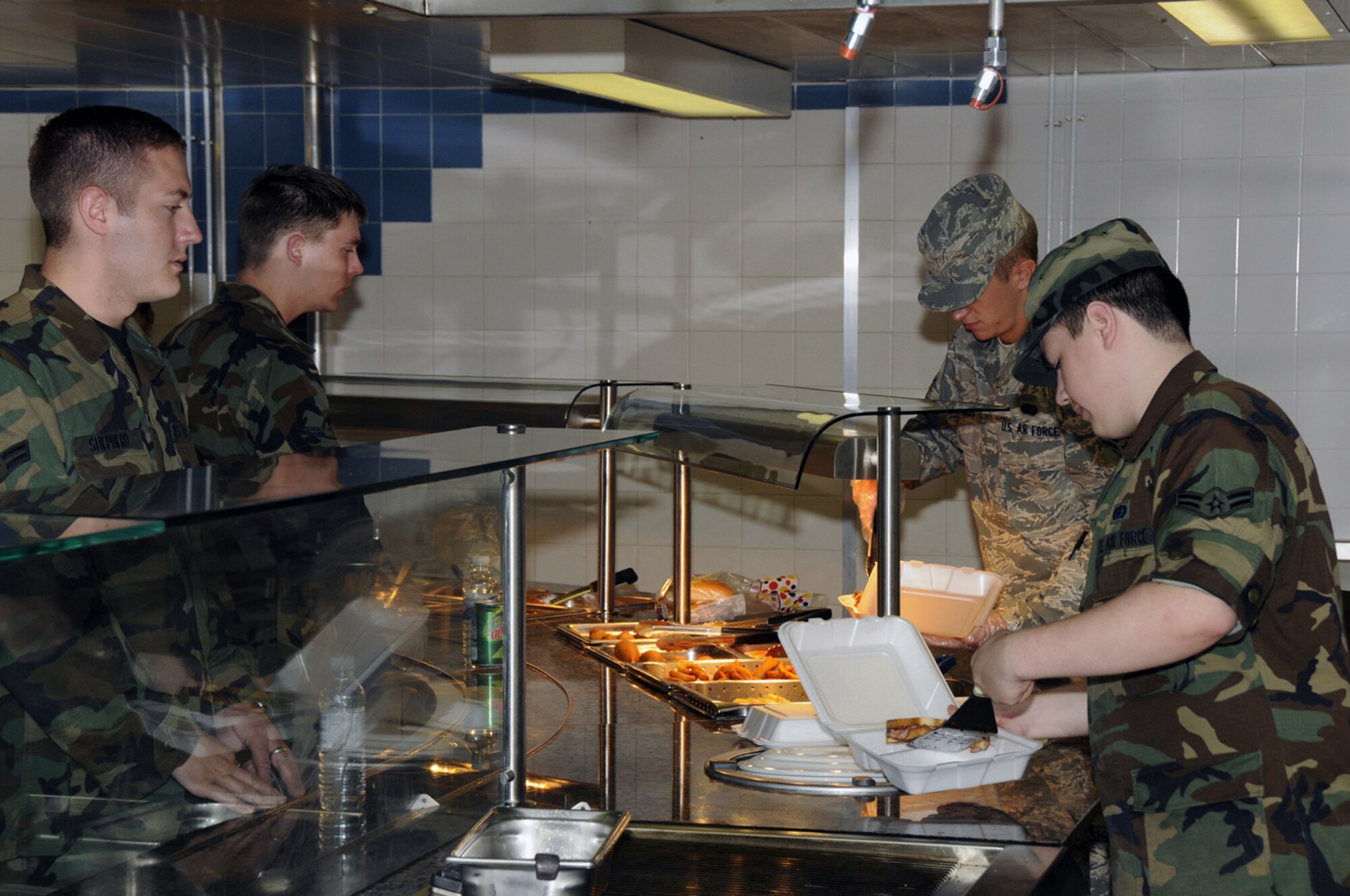 Airman 1st Class Anthone Schwartz 48th Services Squadron, serves a grilled ham and cheese sandwich to Airman 1st Class Kyle Shepherd, 48th Dental Squadron July 8 at RAF Lakenheath, England. The 48th Fighter Wing Knights Table Dinning Facility was recently renovated to improve customer service. (U.S. Air Force photo by Airman Perry Aston)