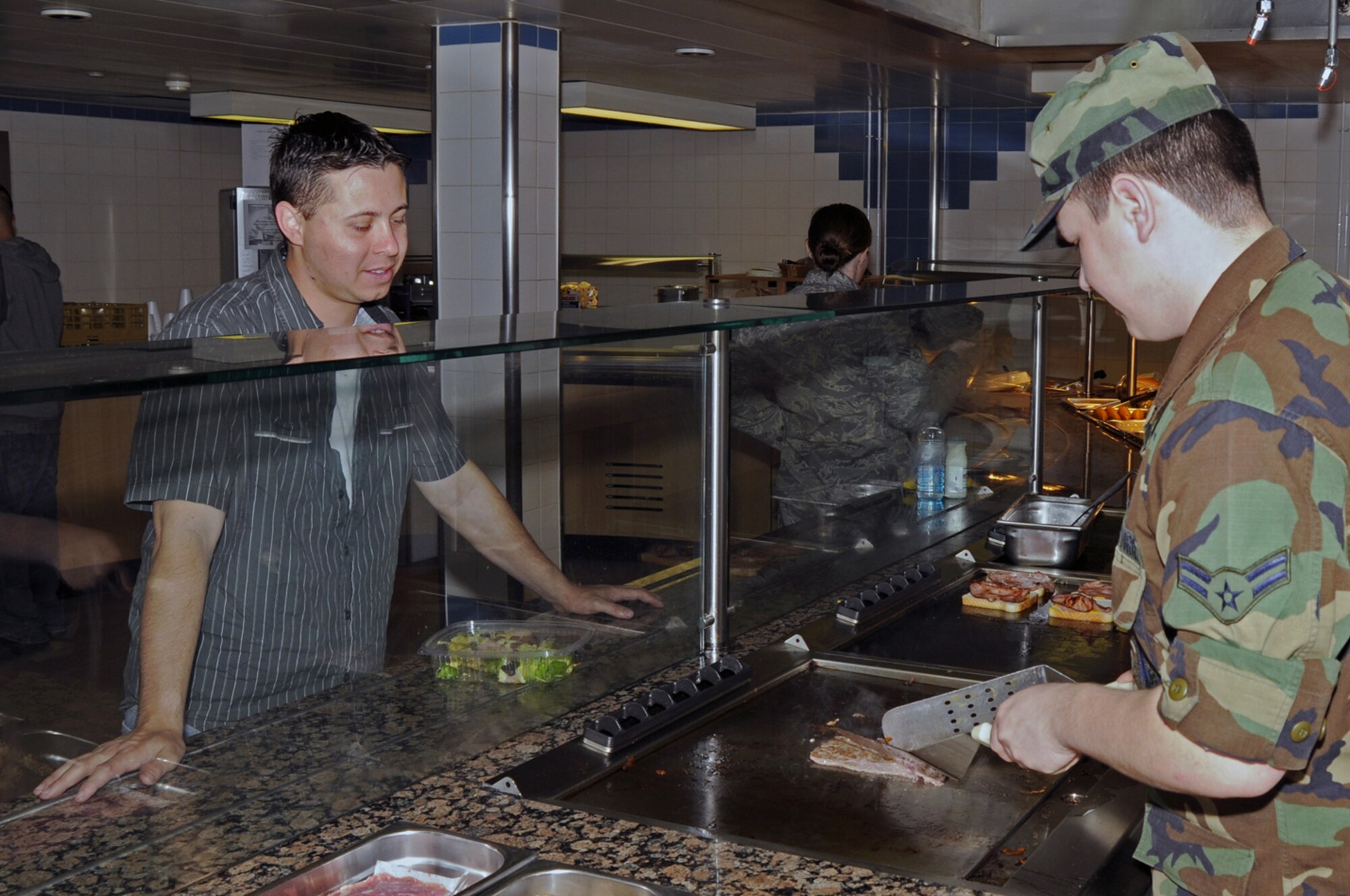 Airman 1st Class Anthone Schwartz 48th Services Squadron, prepares a grilled steak and cheese sandwich for an Airman July 8 at RAF Lakenheath, England. The 48th Fighter Wing Knights Table Dining Facility reopened July 1 with a new salad bar, serving areas and cooking equipment. (U.S. Air Force photo by Airman Perry Aston)
