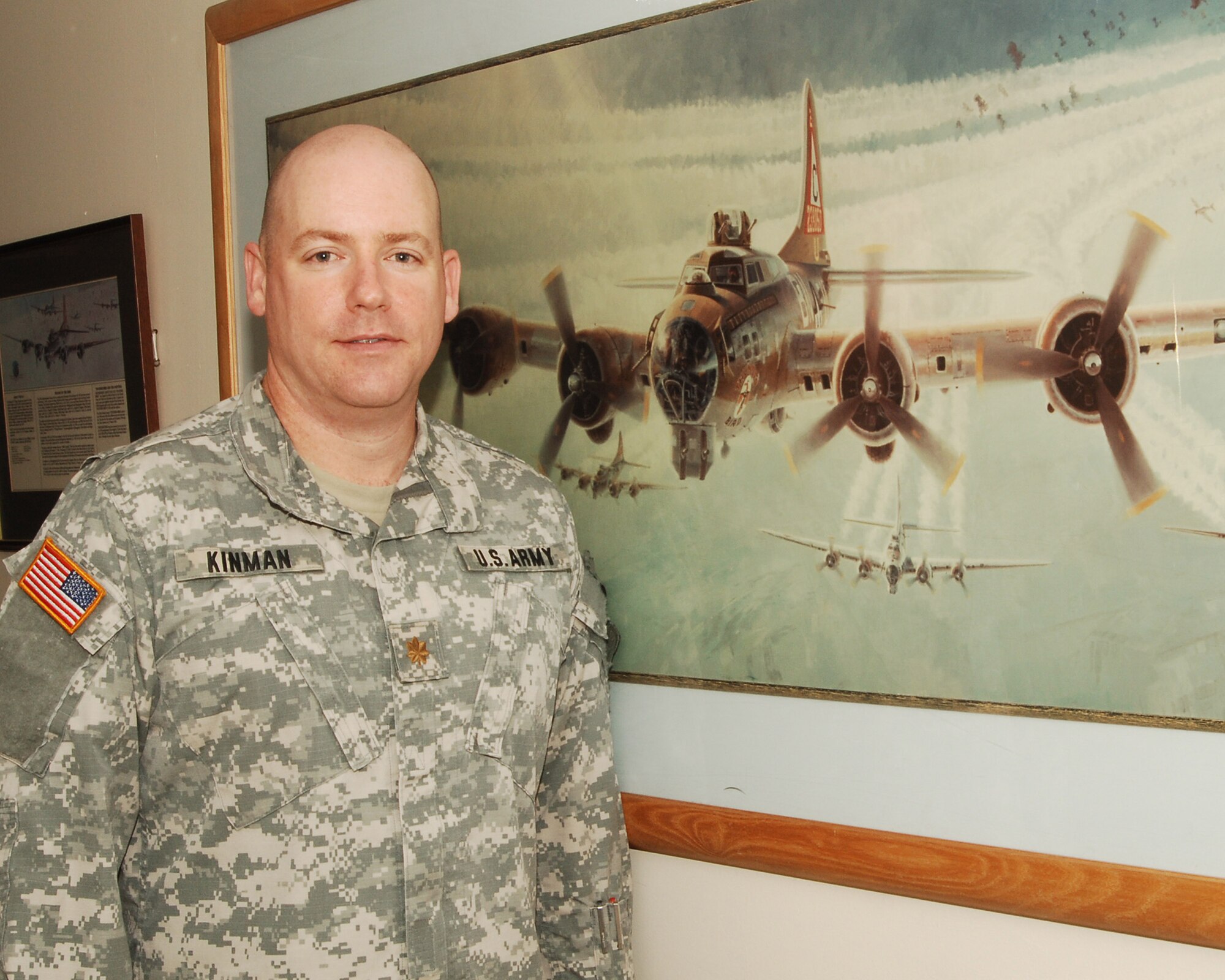 Army Major Bret C. Kinman, a divison chief at the JIOCEUR Analytic Center at Royal Air Force Molesworth, England stands by a replica of the mural of the famed B-17G "Thunderbird" memorialized at the National Air and Space Museum in Washington, DC.   Maj Kinman researched the exact appearance of "Thunderbird" during WWII before building and painting the model.  Detail in the model extends to carefully detailing the wings to show dirt and wear from combat missions.   (U.S. Air Force photo by Staff Sgt. Chad E. Chisholm)