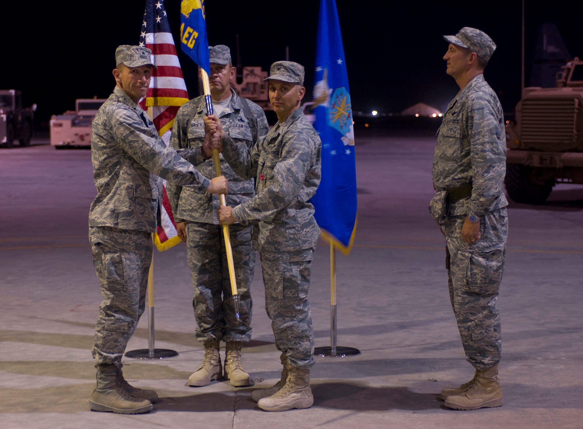 BAGRAM AIR FIELD, Afghanistan -- Col. Thomas Huizenga (center front), commander of the 755th Air Expeditionary Group, passes the 755th AEG's guideon to Brig. Gen. Mike Holmes, commander of the 455th Air Expeditionary Wing, here on July 11, 2008. This symbolic gesture represented Colonel Huizenga relinquishing his command to Col. James Reed (rght). (U.S. Air Force photo by Staff Sgt. Samuel Morse)