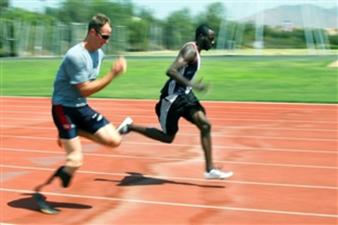 U.S. Navy Petty Officer 1st Class Casey Tibbs trains with a teammate at the ARCO Olympic Training Center in San Diego to prepare himself for his upcoming Paralympics events at the 2008 Olympics in Beijing, July 15, 2008. Tibbs, a cryptologic technician, will represent the United States in several events including shotput, discus and long jump.