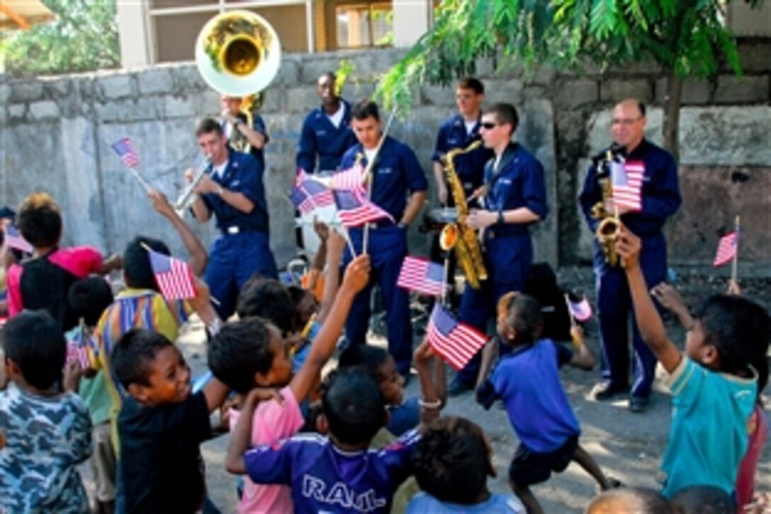 U.S. Navy sailors assigned to the Pacific Fleet band entertain children at a Pacific Partnership engineering civic action program conducted by personnel assigned to the USNS Mercy at Bario Pite Elementary School, Dili, East Timor, July 14, 2008. The USNS Mercy hospital ship is on a four-month deployment to aid participating nations with medical, dental and construction programs. 