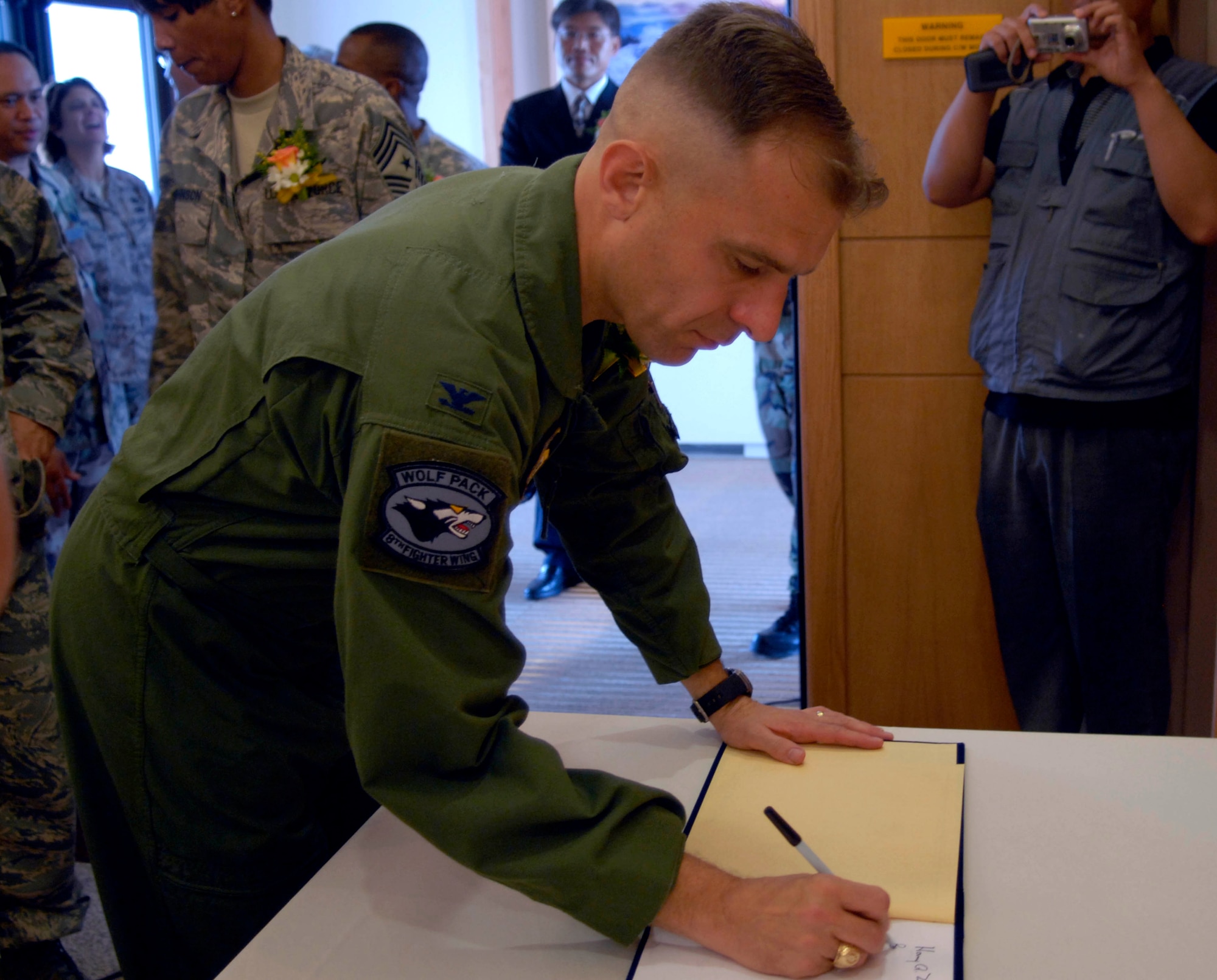 KUNSAN AIR BASE, Republic of Korea--Colonel Bryan "Wolf" Bearden, 8th Fighter Wing commander, signs the welcome book in the new dormitory here July 16. The ceremony dedicates the completion of the Wolf Pack's new FY06 tower dormitory. The project is part of the Air Force's initiative to improve the quality of life for Airmen. (U.S. Air Force photo by Senior Airman Dana Hill) 