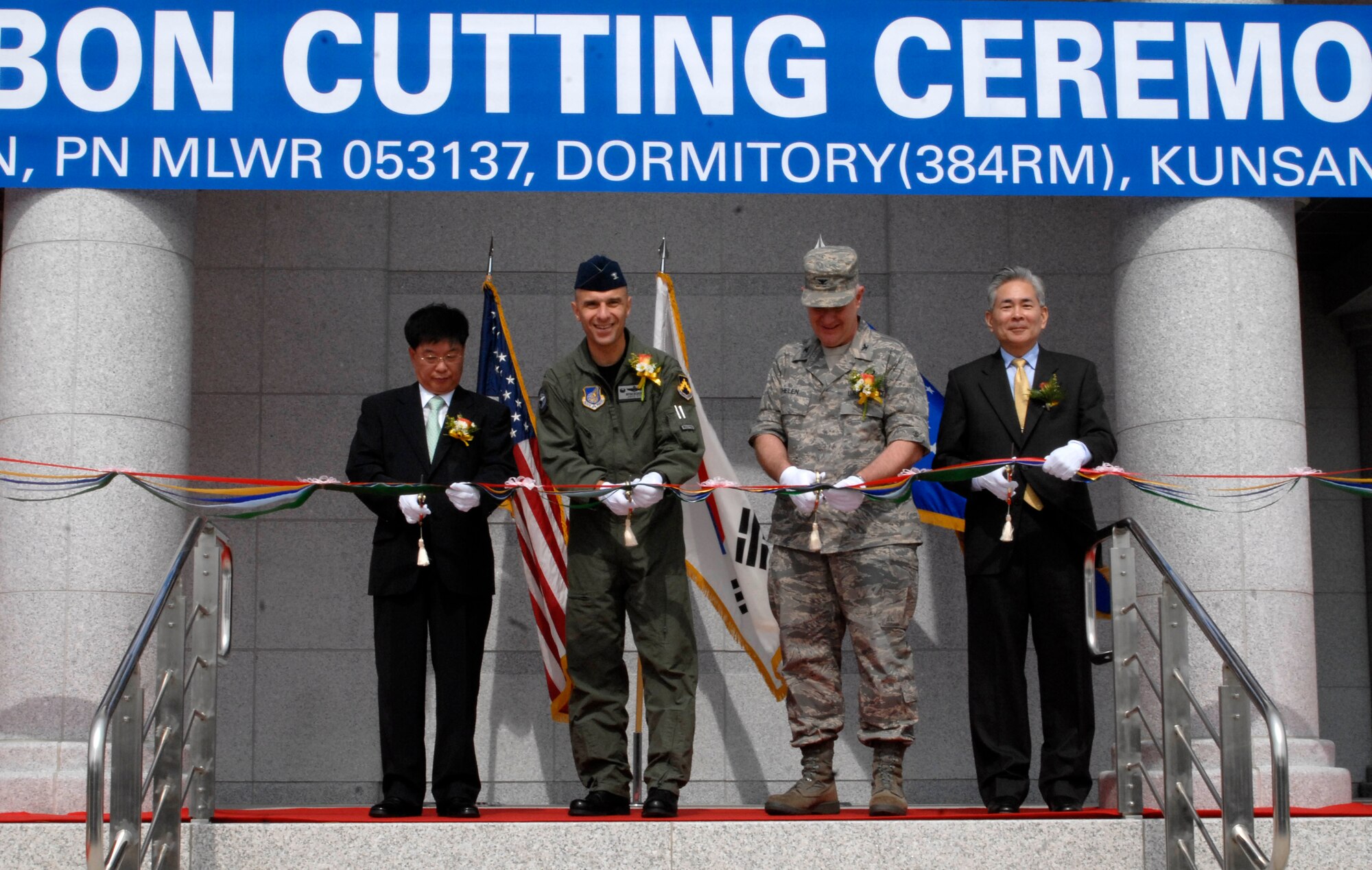 KUNSAN AIR BASE, Republic of Korea--From left to right, Lee Young-Joo, Samsung Construction vice president, Col. Bryan "Wolf" Bearden, 8th Fighter Wing commander, Col. Christopher Thelen, 7th Air Force Installation and Mission Support director, and Jon Iwata, U.S. Army Corps of Engineers cut the ribbon during a new dormitory opening ceremony here July 16. The ceremony dedicates the completion of the Wolf Pack's new FY06 tower dormitory. The project is part of the Air Force's initiative to improve the quality of life for Airmen. (U.S. Air Force photo by Senior Airman Dana Hill)