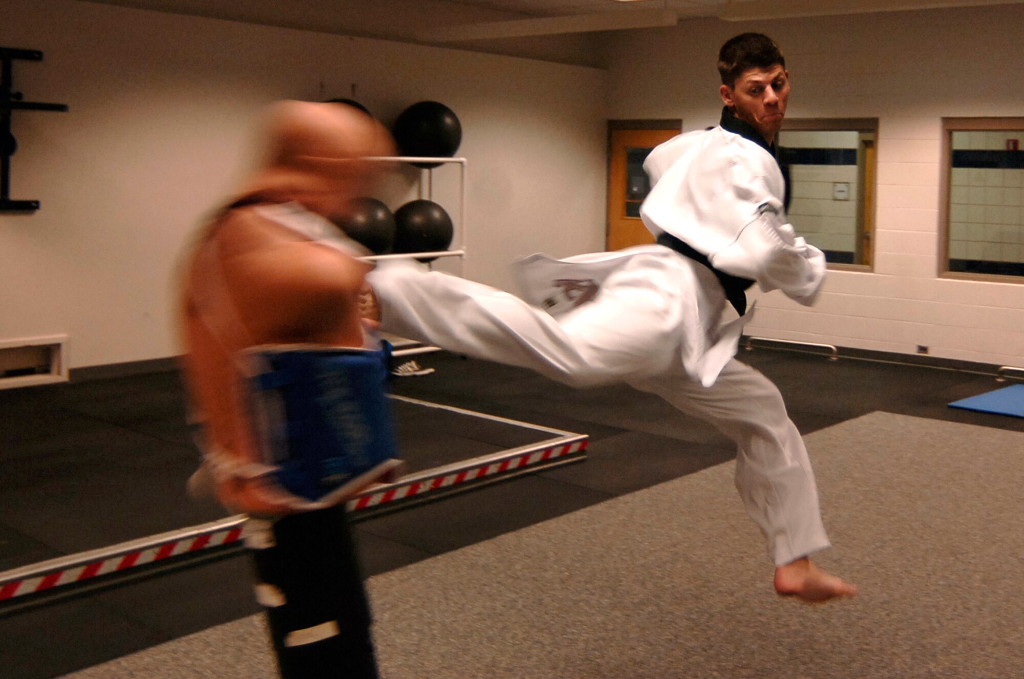 MCCONNELL AIR FORCE BASE, Kan. -- Airman 1st Class Jonathan Scherquist, 22nd Force Support Squadron, demonstrates a jumping back kick during a taekwondo training session, at the base fitness center, July 17. Airman Scherquist feels grateful for the support his family, commander, and squadron has given him to pursue his dream of being a champion taekwondo fighter. (Photo by Airman 1st Class Maria Ruiz)
