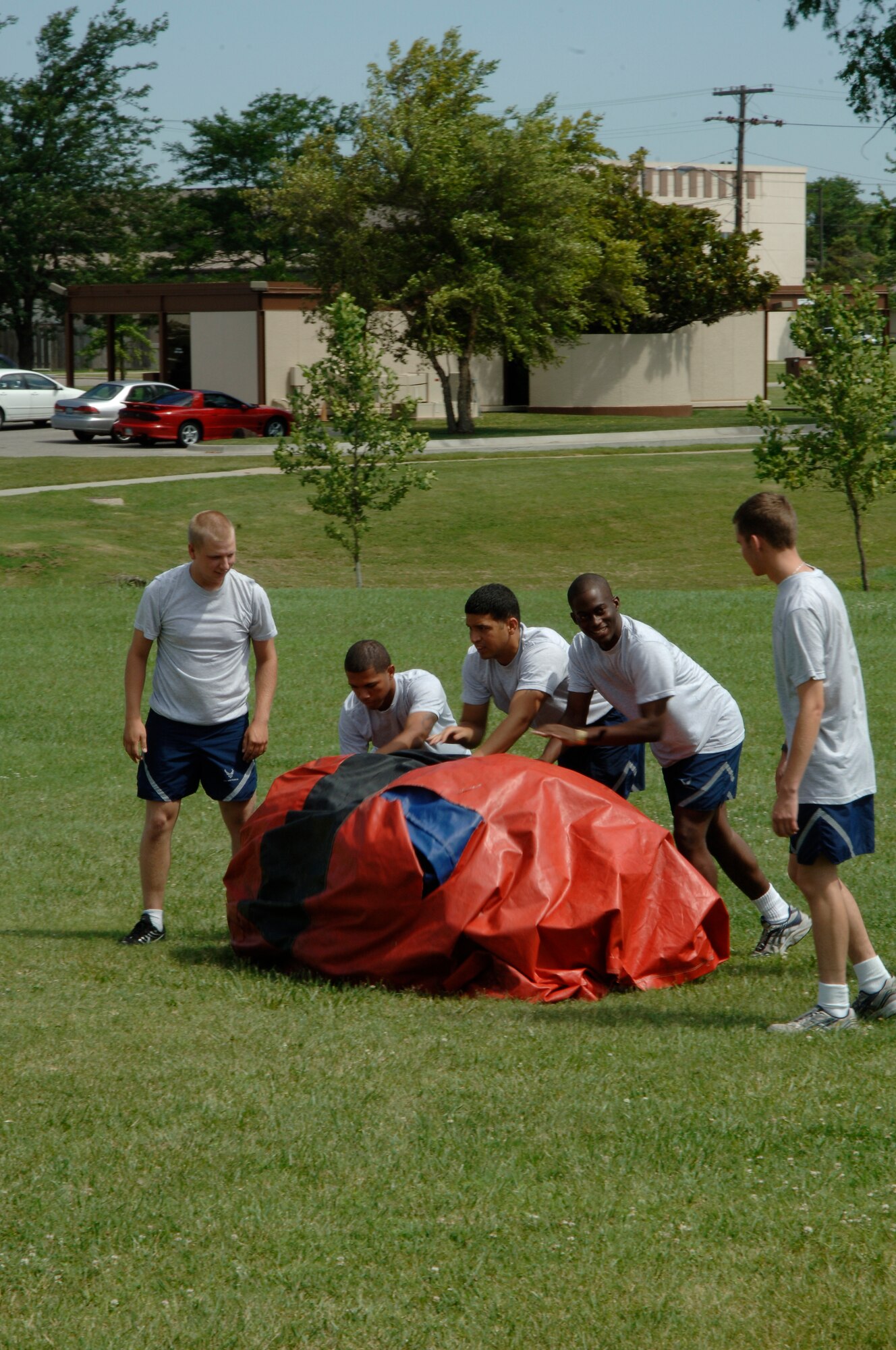 MCCONNELL AIR FORCE BASE, Kan. – Airmen from the First Term Airman Center roll a children’s inflatable bouncy castle to the pavilion area for a 22nd Force Support Squadron picnic, July 11. (Photo by Senior Airman Laura Suttles)