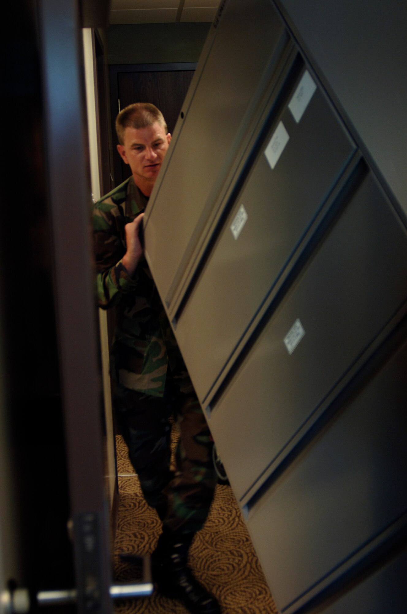 MCCONNELL AIR FORCE BASE, Kan. – Master Sgt. Mike Radke, 22nd Force Support Squadron, moves a file cabinet into Bldg. 1120, July 11. Building 1120 is the new location of the 22nd FSS commander, Lt. Col. Sonya Collins and squadron leadership. (Photo by Senior Airman Laura Suttles)