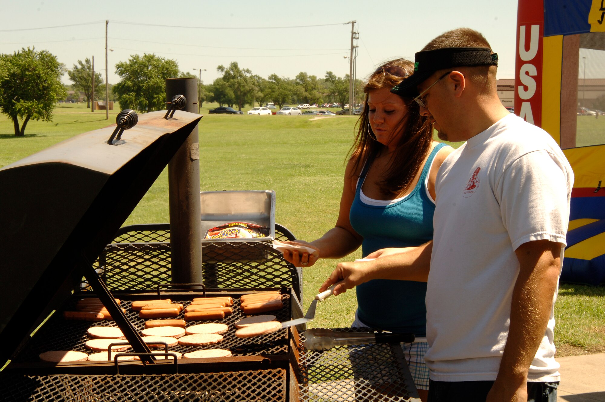 MCCONNELL AIR FORCE BASE, Kan. – Tech. Sgt. Eric Bias and Staff Sgt. Tennille Benton, grill hamburgers and hotdogs at a picnic celebration held for members of the newly formed 22nd Force Support squadron, here, July 11. (Photo by Senior Airman Laura Suttles)