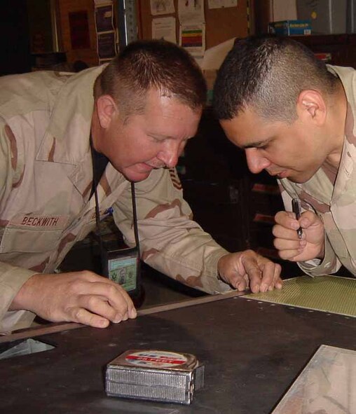 Tech. Sgt. Beckwith and Tech. Sgt. Tello fabricate a repair for an EC-135 while on temporary duty in Saudi Arabia.  (Courtesy photo)