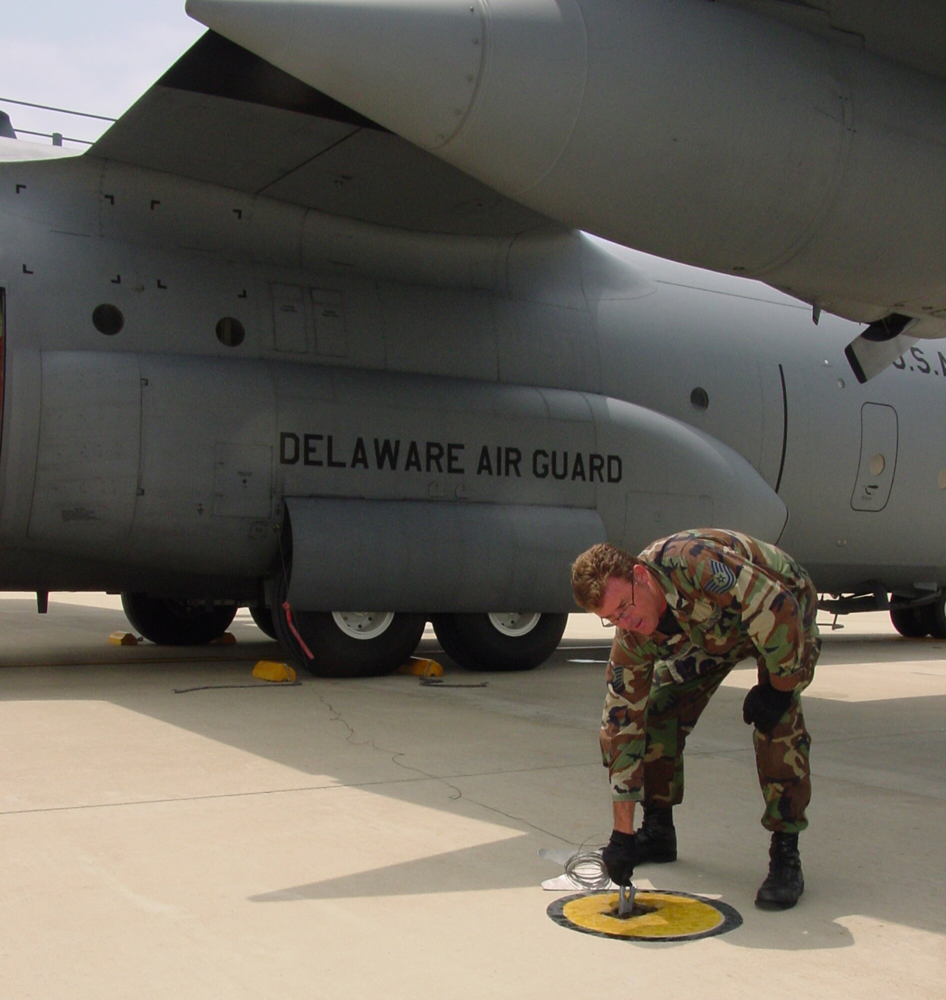 Technical Sgt. Scott Nybakken, crew chief for C-130 aircraft # 213, Delaware Air National Guard, attaches a ground wire to protect the aircraft against inadvertant static charges. The aircraft just went over the 10,000 hour flying mark on June 5, 2008 to become the aircraft with the most flying time in the unit's C-130 fleet since eight new C-130H aircraft arrived in the mid-1980s.