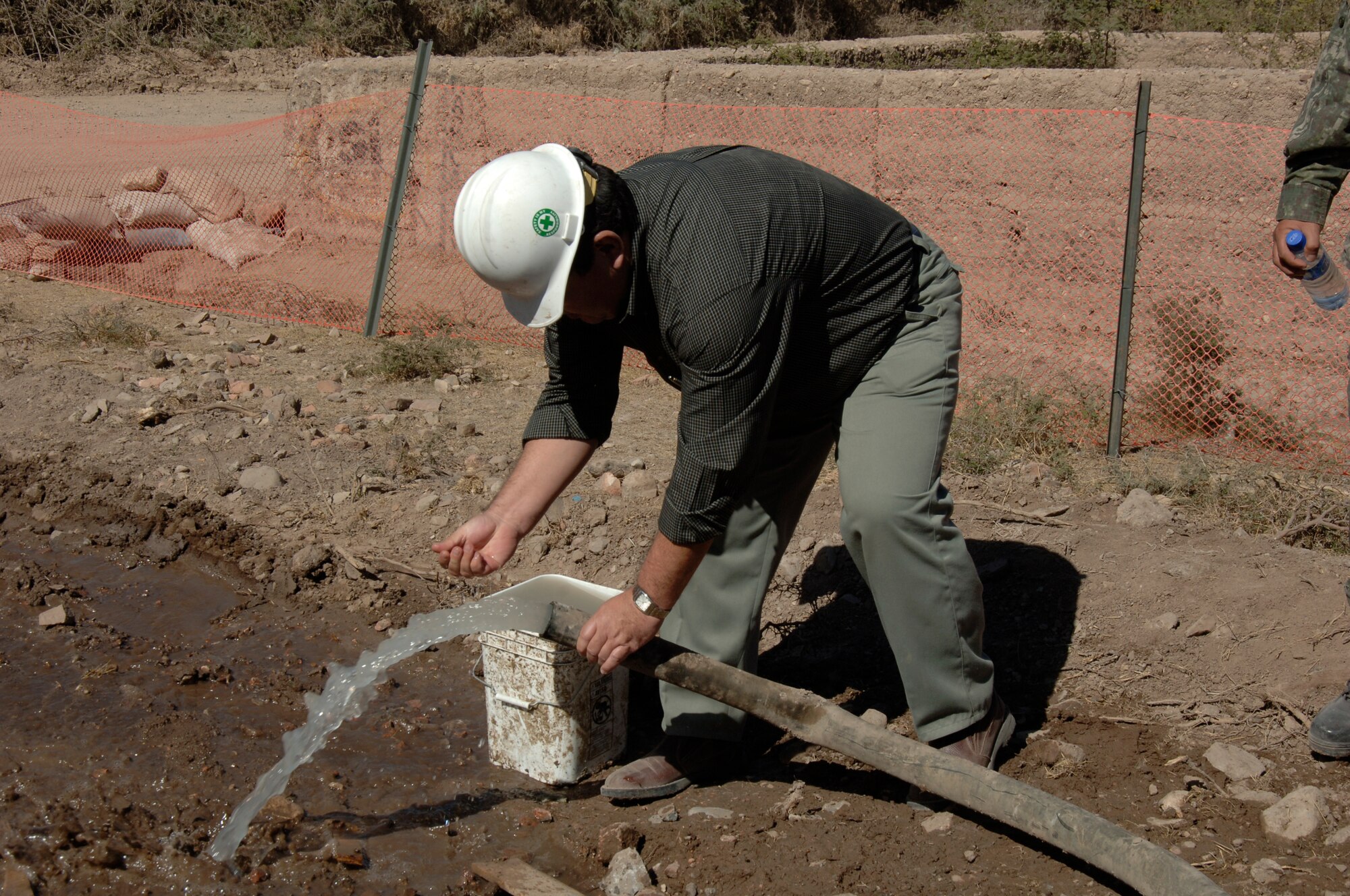 Dr. Luis Cabeña, Chief of Staff to the Minister of Defense of Peru, takes a closer look at the water Navy Seabees drilled in Luricocha, Peru, July 13.  The Navy Seabees, deployed from Gulfport, Miss., are drilling two wells in support of New Horizons - Peru 2008, a partnered humanitarian effort by the U.S. and Peru to bring relief to underprivileged Peruvians. (U.S. Air Force Photo/1st Lt. Mary Pekas)