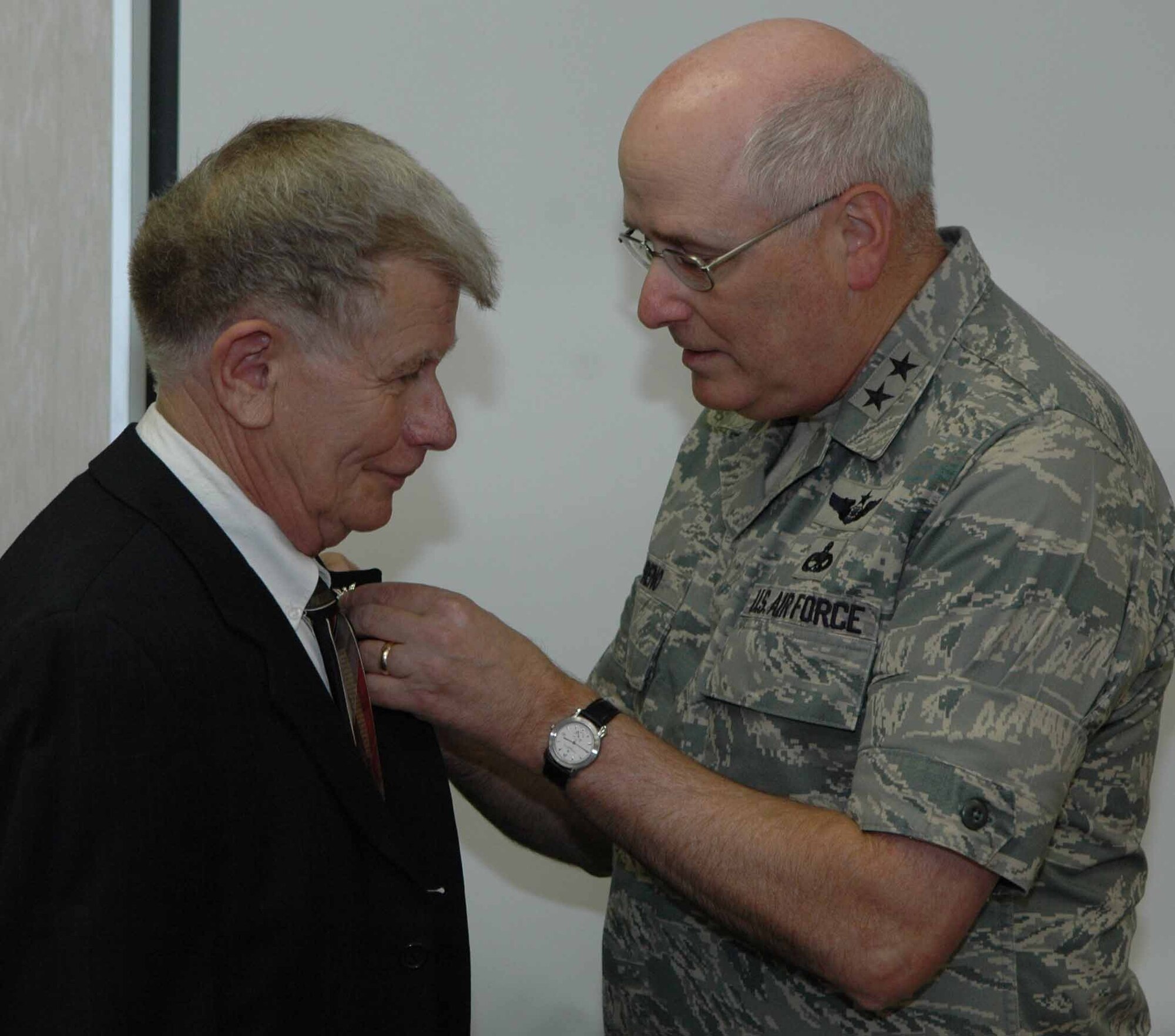 In a ceremony held July 3, Oklahoma City Air Logistics Center commander, Maj. Gen. Loren Reno, presents a 40-year Federal Service pin to Larry Tarrant, an aerospace engineer in the E-3 International Flight, 557th Aircraft Sustainment Squadron. Mr. Tarrant began his Civil Service career in 1968 as an aerospace engineer assigned to the Aircraft Directorate, Oklahoma City Air Materiel Area now known as the Oklahoma City Air Logistics Center.  (Air Force photo by Ron Mullan)