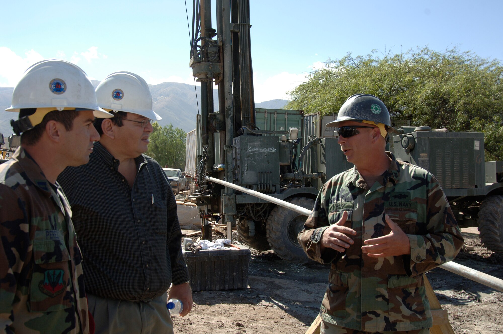 Petty Officer 1st Class Mark Goff, Task Force New Horizons lead driller, explains the Navy Seabee's well-drilling progress at Luricocha, Peru, July 13, to Dr. Luis Cabeña, Chief of Staff to the Peruvian Ministry of Defense.  The Seabees are supporting New Horizons - Peru 2008, a partnered effort between the U.S. and Peru to bring relief to underprivileged Peruvians. (U.S. Air Force Photo/1st Lt. Mary Pekas) 