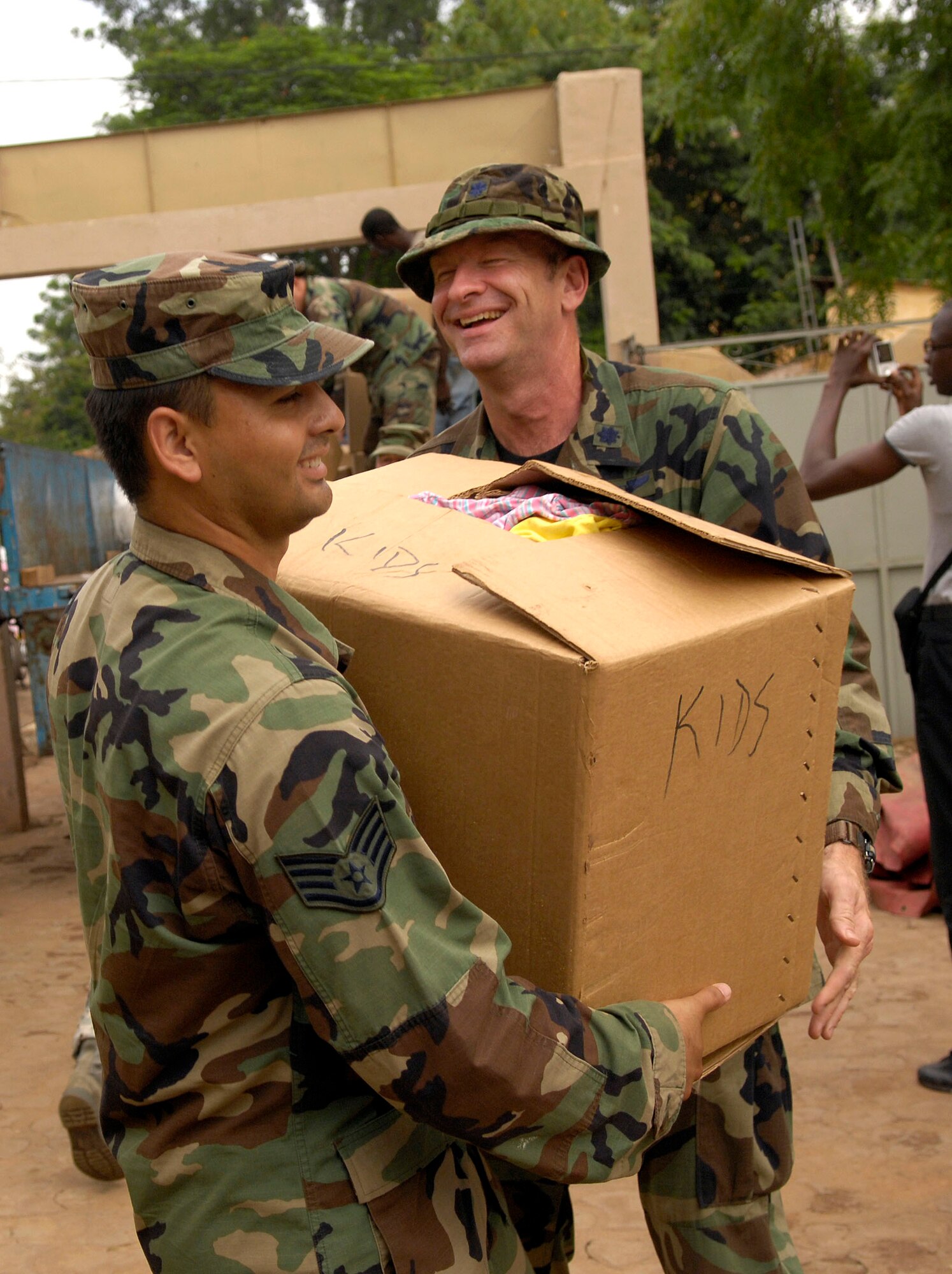 BAMAKO, Mali -- Lt. Col. Joseph Connolly hands Staff Sgt. Carlos Lomeli a box of children's clothing to be donated to the Bamako National Orphanage, July 16, 2008.  Airmen from the 31st Medical Group, Aviano Air Base, Italy, collected more than 2,500 pounds of clothing, toys and shoes to distribute at Bamako orphanages.  Colonel Connolly is deployed from the 31st Medical Group, Aviano Air Base, Italy.  Sergeant Lomeli is deployed from the 48th Medical Group, Royal Air Force, Lakenheath, England.  (U.S. Air Force photo/Senior Airman Michael S. Dorus)