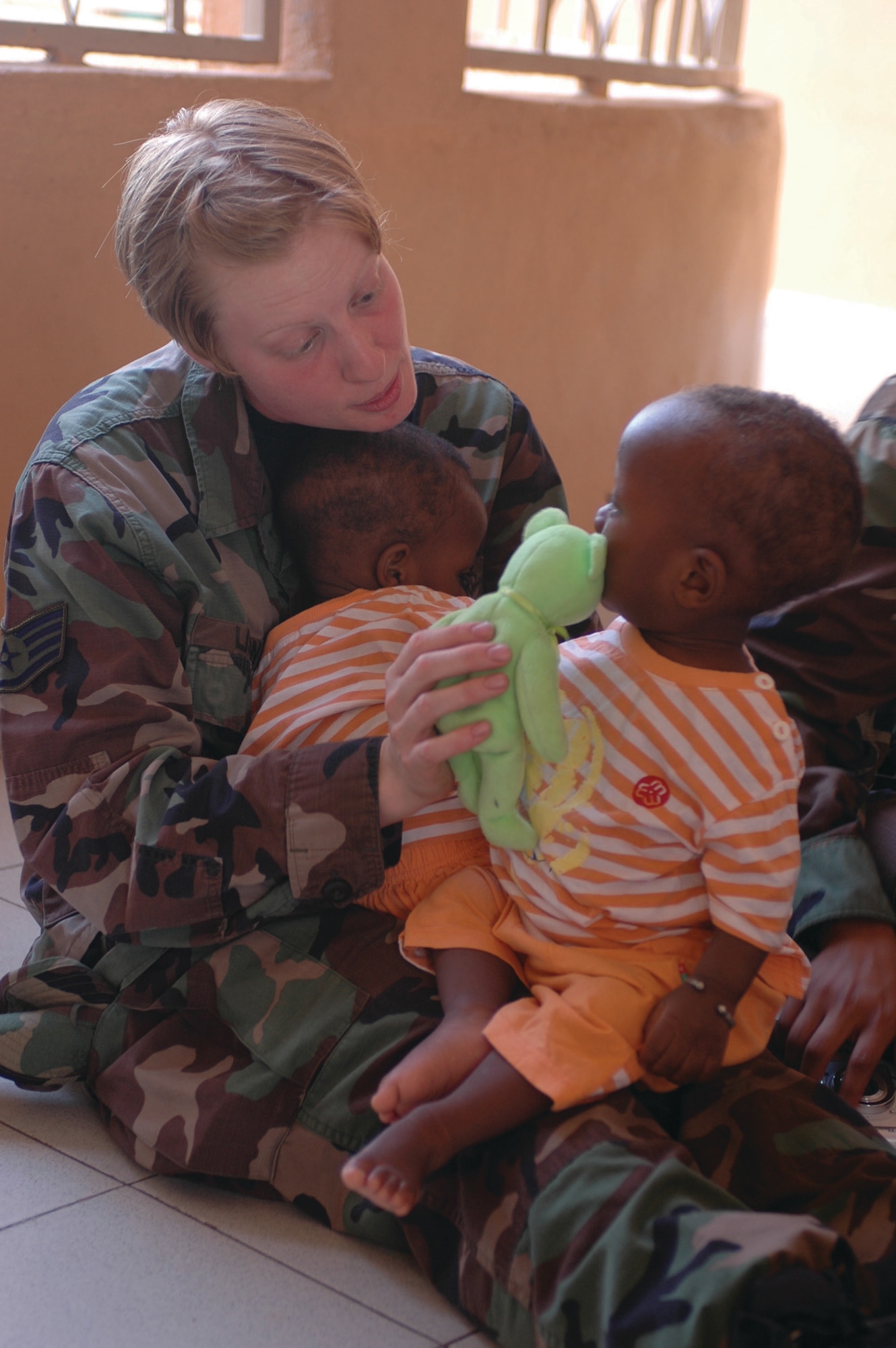 BAMAKO, Mali -- Staff Sgt. Churyl Liston plays with two small children at a local orphanage in Bamako, Mali, July 16. Sergeant Liston is a medical technician assigned to the 31st Medical Group, Aviano Air Base, Italy. (U.S. Air Force photo/Senior Airman Justin Weaver)