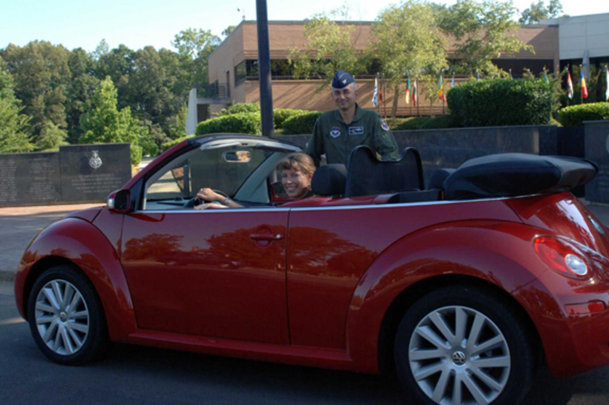 Colonel Roger Watkins, 14th Flying Training Wing commander, and his wife, Leslie, sit in front of Smith Plaza at the 14th FTW Headquarters building with Mrs. Watkins’ new car. (U.S. Air Force photo by Airman 1st Class John Parie)