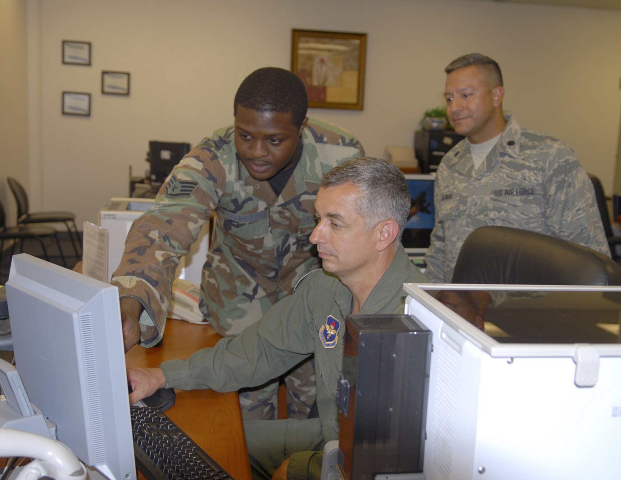 Staff Sgt. Christopher Washington, 14th Force Support Squadron, shows Col. Roger Watkins, 14th Flying Training Wing commander, how to issue a CAC card during his tour of the Military Personnel Flight. (U.S. Air Force photo by Elizabeth Owens)