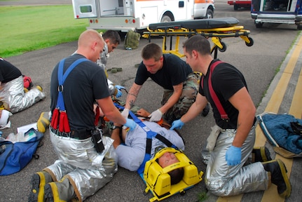 SOTO CANO AIR BASE, Honduras ? Joint Task Force-Bravo fire fighters and Medical Element personnel work to stabilize a simulated victim of a C-21 crash July 10. Members from JTF-Bravo MEDEL were responsible for caring for the simulated victims and performing proper triage.  MEDEL was part of a base-wide exercise that simulated a mass casualty, anti-terrorism and force protection scenarios. (U.S. Air Force photo by Staff Sgt. Joel Mease)