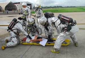 SOTO CANO AIR BASE, Honduras ? Joint Task Force-Bravo fire fighters work to stabilize a simulated victim of a C-21 crash July 10. The fire fighters were charged with the task to put out a simulated fire and rescue the trapped occupants of the simulated plane. The fire fighters were part of a base-wide exercise that simulated a mass casualty, anti-terrorism and force protection scenarios. (U.S. Air Force photo by Staff Sgt. Joel Mease)