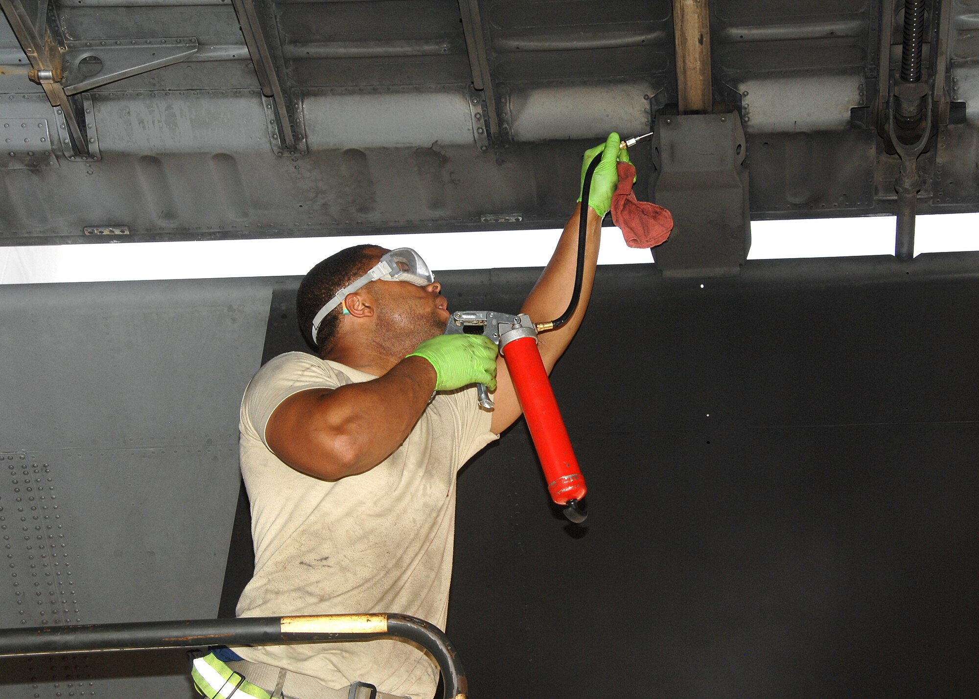 SOUTHWEST ASIA -- Airman 1st Class Corey Robinson, a crew chief assigned to the 386th Expeditionary Aircraft Maintenance Squadron, lubricates the flaps of a C-130 Hercules on July 17 at a base in Southwest Asia. Airman Robinson is deployed from the 317th Airlift Group, Dyess Air Force Base, Texas. (U.S. Air Force photo/Tech. Sgt. Raheem Moore)
