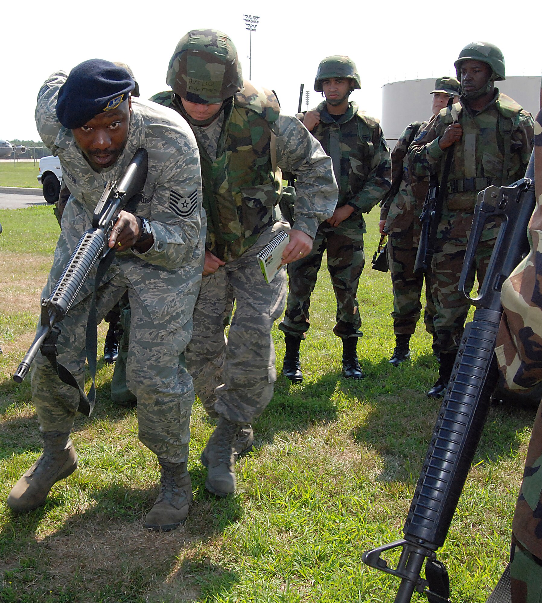 Tech Sgt. Gegrory Pendleton, 436th Security Forces Squadron, demonstrates post bug-out procedures to 512th Airlift Wing members outside Building 910 here.  Wing reservisits participated in various refresher training sessions over the July Unit Training Assembly in preparation for the upcoming Operational Readiness Inspection. (U.S. Air Force photo/Staff Sgt. Steve Lewis)