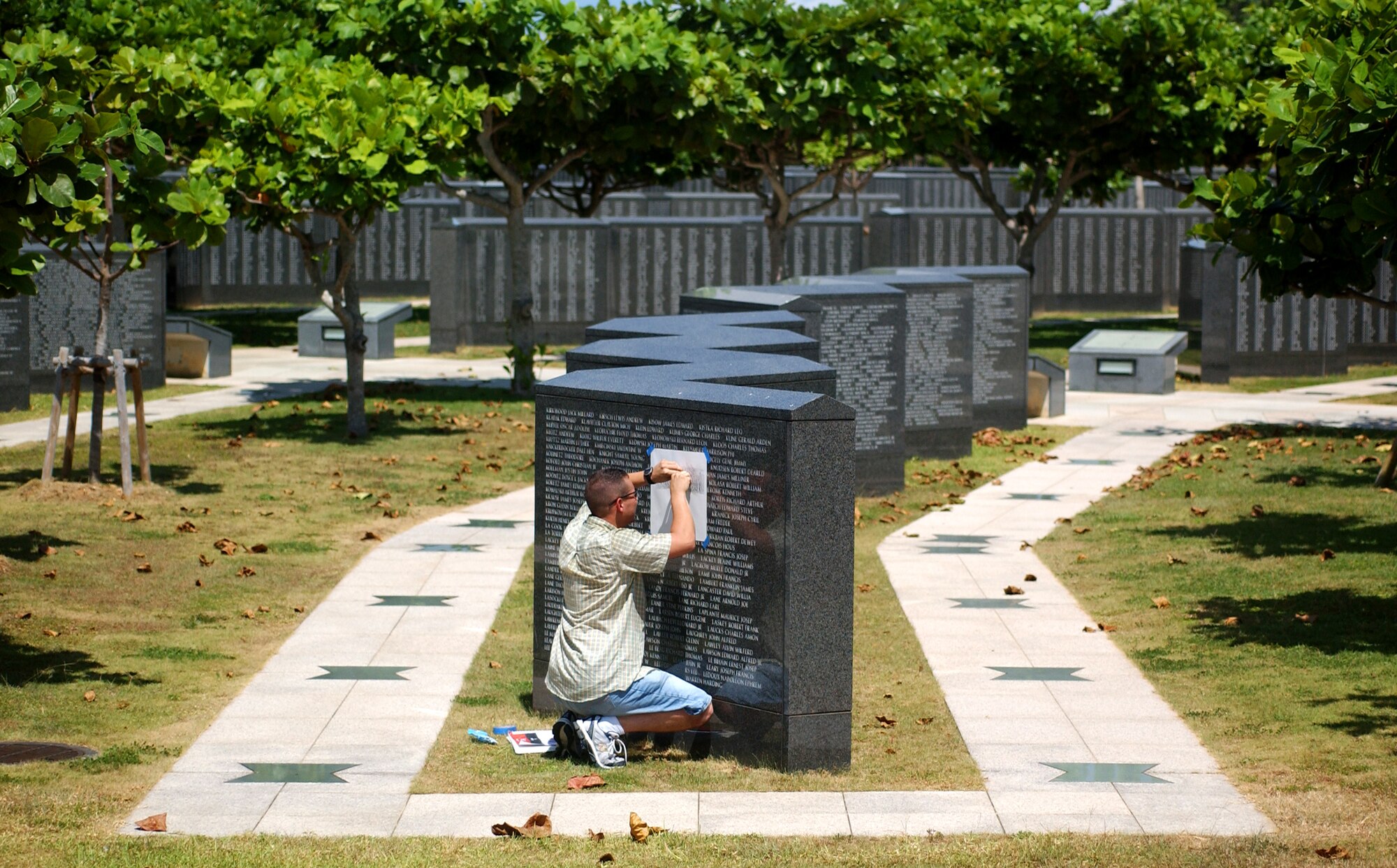 Tech. Sgt. Victor Follis from the 18th Maintenance Group does pencil rubbings and takes photographs of names requested by relatives or friends who had loved ones serving during the battle of Okinawa.  (U.S. Air Force photo/Tech. Sgt. Rey Ramon) 