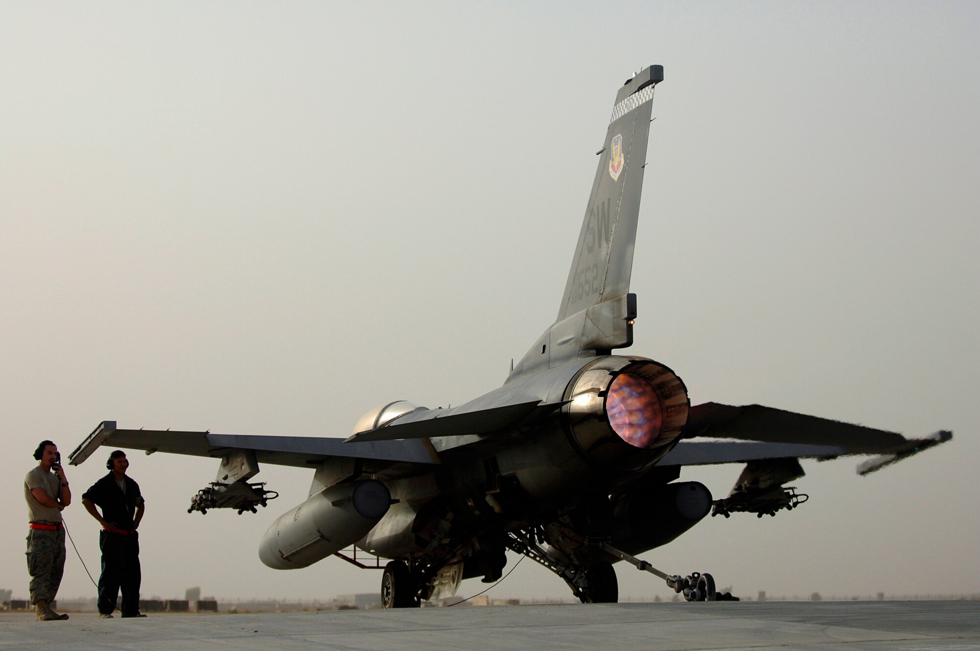 JOINT BASE BALAD, Iraq -- Senior Airman Graham Willis and Staff Sgt. Ferdinand Brown, 77th Aircraft Maintenance Unit engine mechanics, watch as an F-16 Fighting Falcon roars in full afterburner during an engine run up here, July 16. During a run up the mechanics testing all of the engine settings and gauges that pilot use during combat missions. Doing so will ensures no components faultier and the jet is ready for operational use. Airman Willis and Sergeant Brown are both deployed from Shaw Air Force Base, S.C. (U.S. Air Force photo/Senior Airman Julianne Showalter)