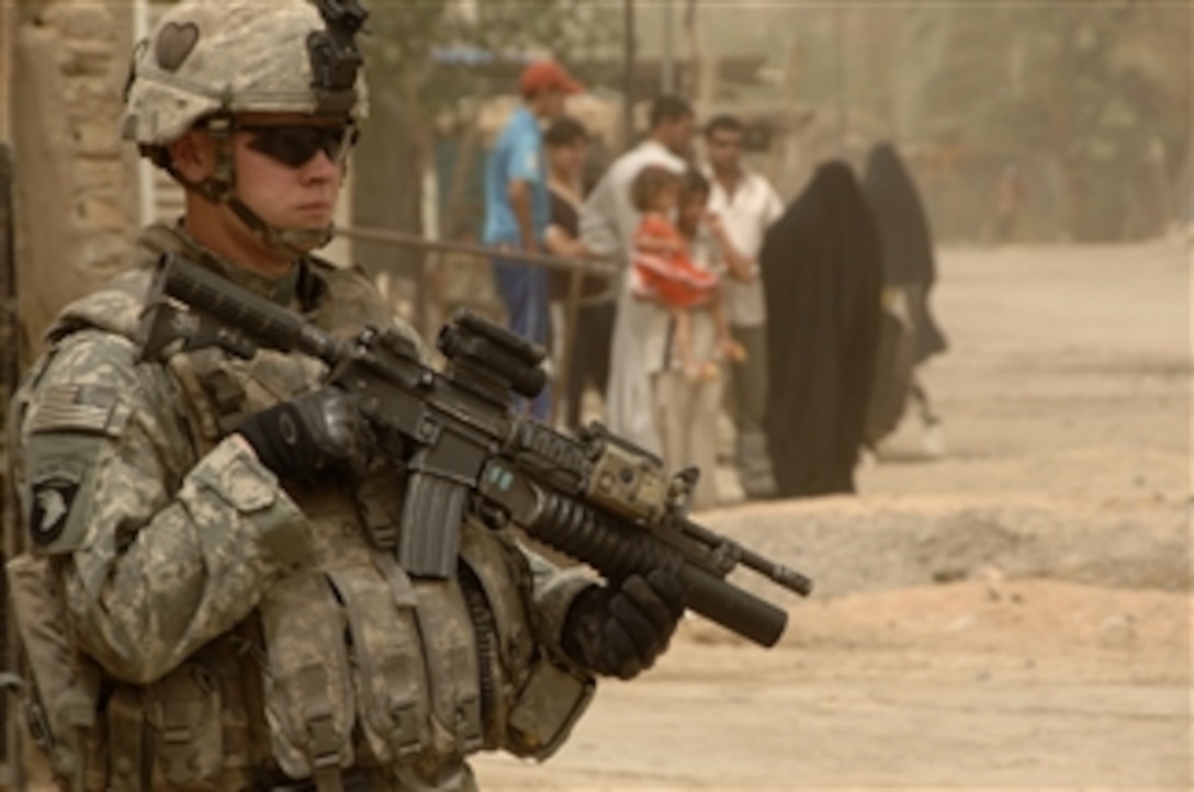 U.S. Army Sgt. Clayton Armstrong provides security during a combined patrol with Iraqi police in the Gazaliyah district of Baghdad, Iraq, on July 8, 2008.  This patrol is also a mission to distribute micro-grant applications to area business owners.  Armstrong is assigned to the 4th Platoon, Bravo Troop, 1st Squadron, 75th Cavalry Regiment, 2nd Brigade Combat Team, 101st Airborne Division.  
