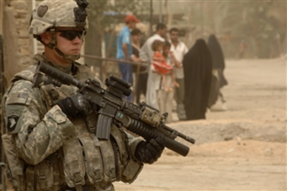 U.S. Army Sgt. Clayton Armstrong provides security during a combined patrol with Iraqi police in the Gazaliyah district of Baghdad, Iraq, on July 8, 2008.  This patrol is also a mission to distribute micro-grant applications to area business owners.  Armstrong is assigned to the 4th Platoon, Bravo Troop, 1st Squadron, 75th Cavalry Regiment, 2nd Brigade Combat Team, 101st Airborne Division.  