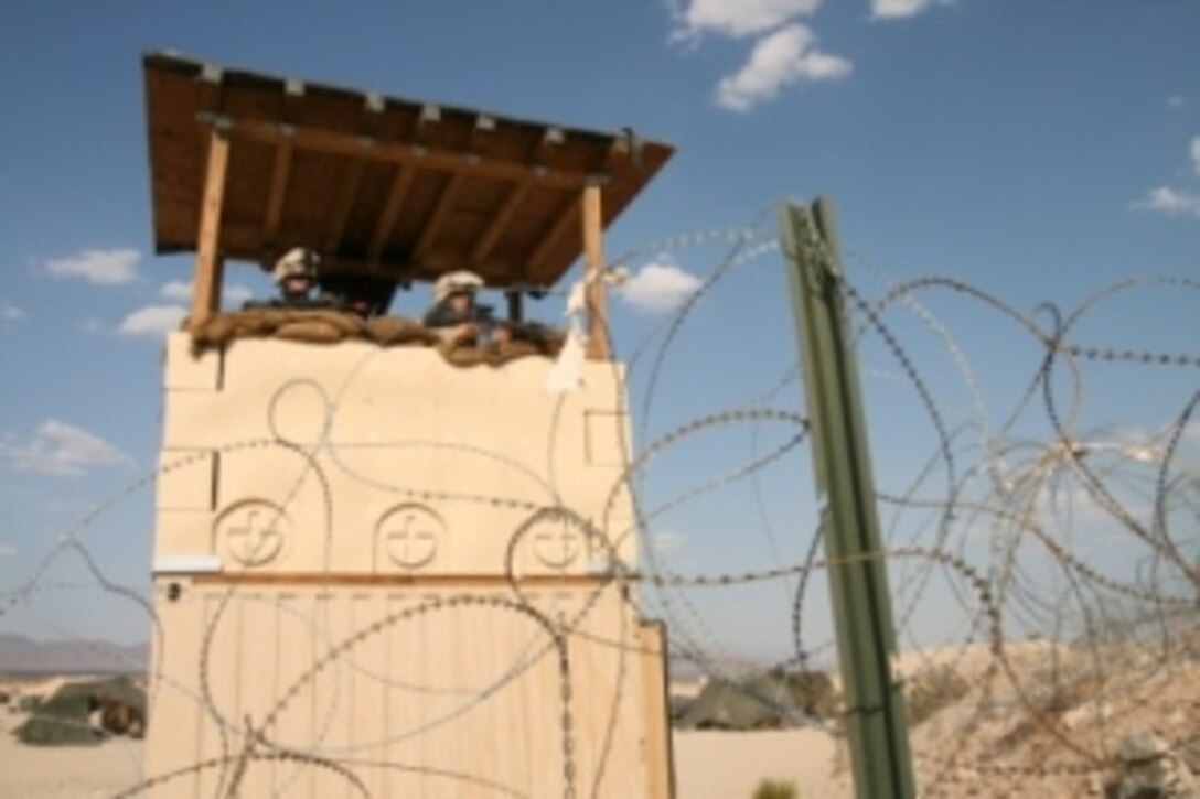 Lance Cpl. Graham Ferro (left) and Cpl. Doug Osberg from Weapons Company, 2nd Battalion, 25th Marine Regiment scan the desert terrain, guarding their forward operating base during a battalion-level exercise at Marine Corps Air-Ground Combat Center in Twentynine Palms, Calif. July 17.