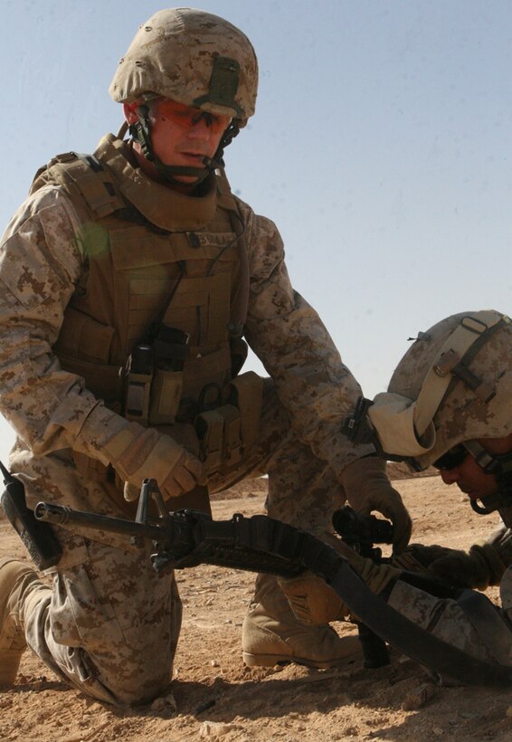 Gunnery Sgt. Eric Brown, the company gunnery sergeant with Company G, Task Force 2nd Battalion, 2nd Marines, Regimental Combat Team 5, helps one of his Marines zero an RCO (Rifle Combat Optic) at Camp Al Qaâ??im, Iraq, July 18. After each Marine had properly adjusted his RCO, they began an urban assault exercise.