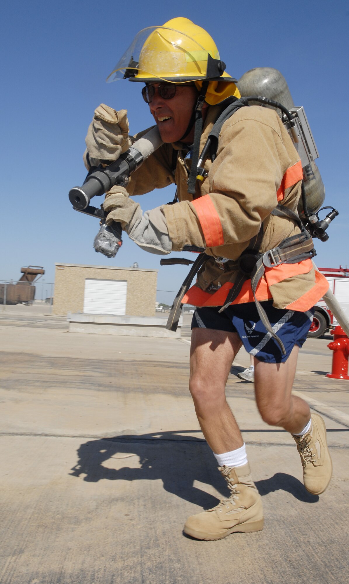 Colonel Barry Simon, 17th Medical Group commander, drags a hose approximately fifty feet where a target awaits the spray of his hose during the Rookie Firefighter Combat Challenge July 18. (U.S. Air FOrce photo by Senior Airman Kamaile Chan)