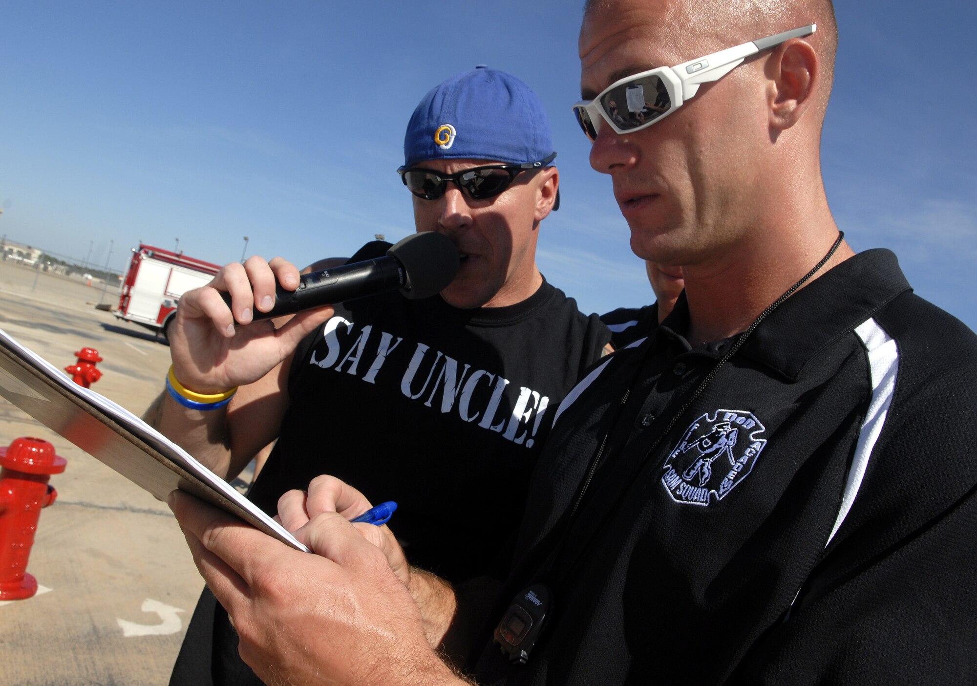 Technical Sergeant Joel Harr and Marine Staff Sgt. Charles Ammon, fire school instructors, record scores during the July 12 Rookie Firefighter Combat Challenge. (U.S. Air FOrce photo by Senior Airman Kamaile Chan)