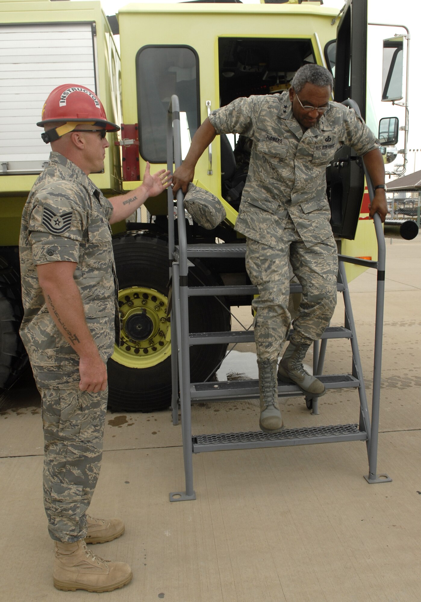 Technical Sergeant Joel Harr, 312th Training Squadron fire instructor, helps Maj. Gen. Alfred Flowers, 2nd AF commander, during his visit to the fire school training grounds. (U.S. Air Force photo by Senior Airman Kamaile Chan)