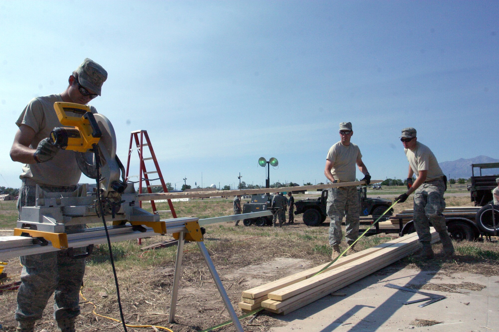 Senior Airman Steven Hyer (left), Master Sgt. Jason Wilson (middle) and Staff Sgt. Steven Azevedo, from the 419th Civil Engineer Squadron, cut a board while building a shelter during a training exercise during the July Unit Training Assembly. The exercise gave CE members a chance to practice crucial skills and receive important training. Also during the exercise, CE personnel assembled a mat used for repairing damaged runways, and filled in a crater from a simulated runway bomb. 
