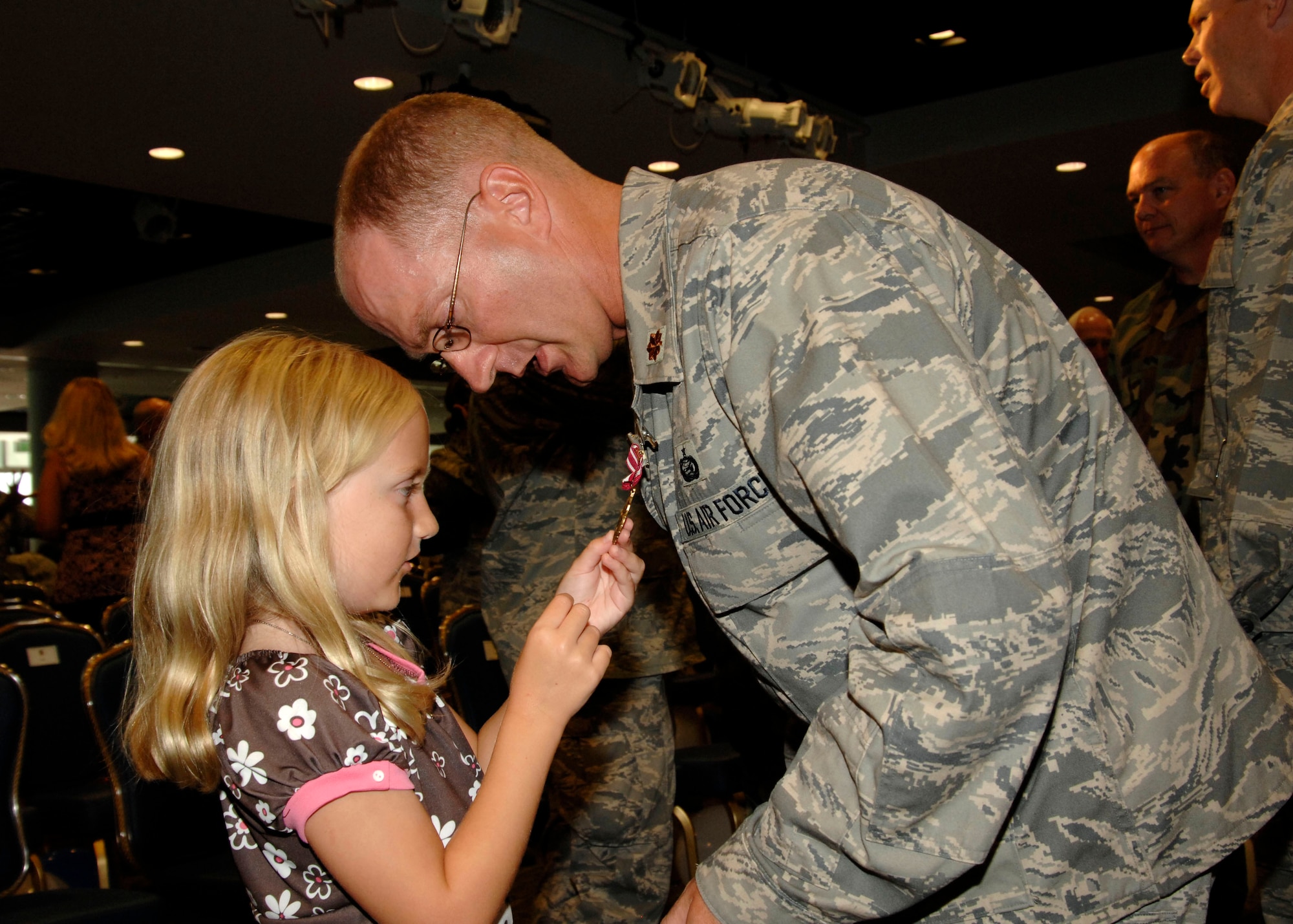 Rebecca Mann, daughter of Air Force Major, Shawn Mann, admires the Meritorious Service Medal her father received during the ceremony, “Welcoming Home of the Troops,” at Los Angeles Air Force Base. Major Mann was deployed to Bagram, Afghanistan and is with the 61st Mission Support Squadron at Los Angeles AFB, Space and Missile Systems Center.  (Photo by Lou Hernandez)